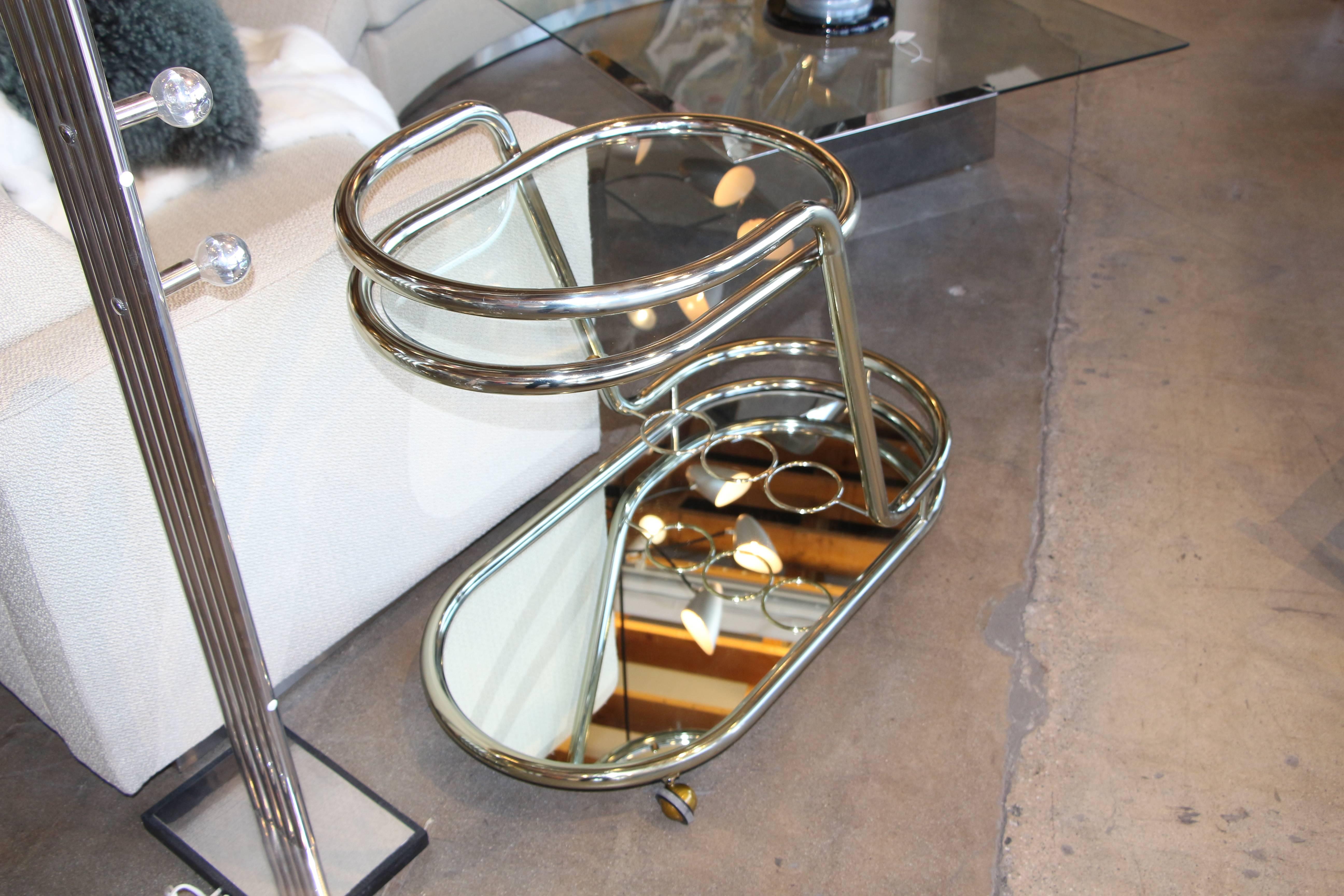 A pretty Champagne colored lacquered chrome cart from the 1980s out of a famous palm springs hotel designed by Albert Frey and redone in the 1980s by Donald Lloyd Smith. This bar cart is from the 1980s remodel. We had to replace the casters which