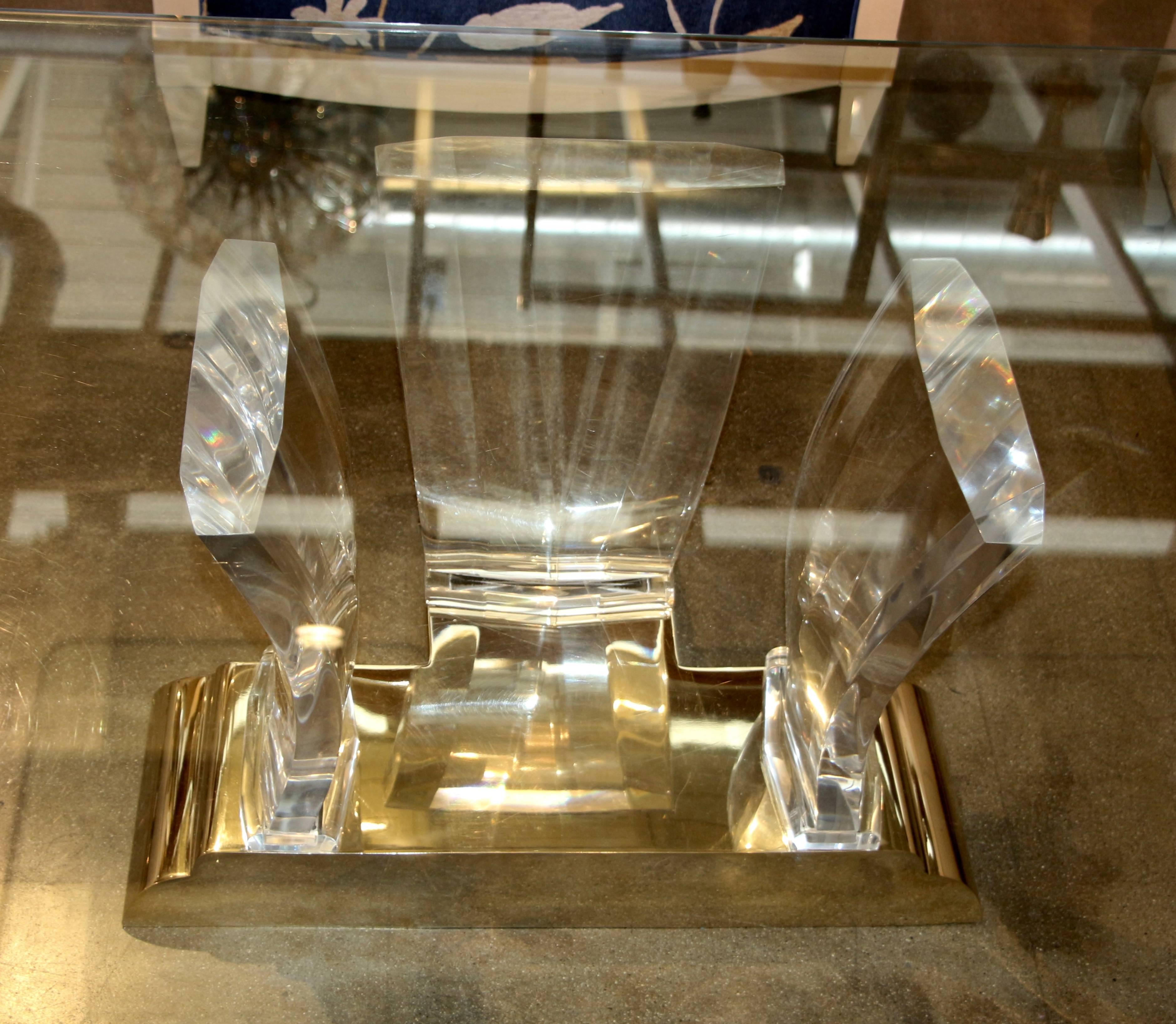 A stunning coffee table by Bigelow. Each end features three thick Lucite supports held in place by a polished bronze base. We put an old piece of glass for look, as we are basically selling the bases. It will be cheaper not to ship a piece of glass