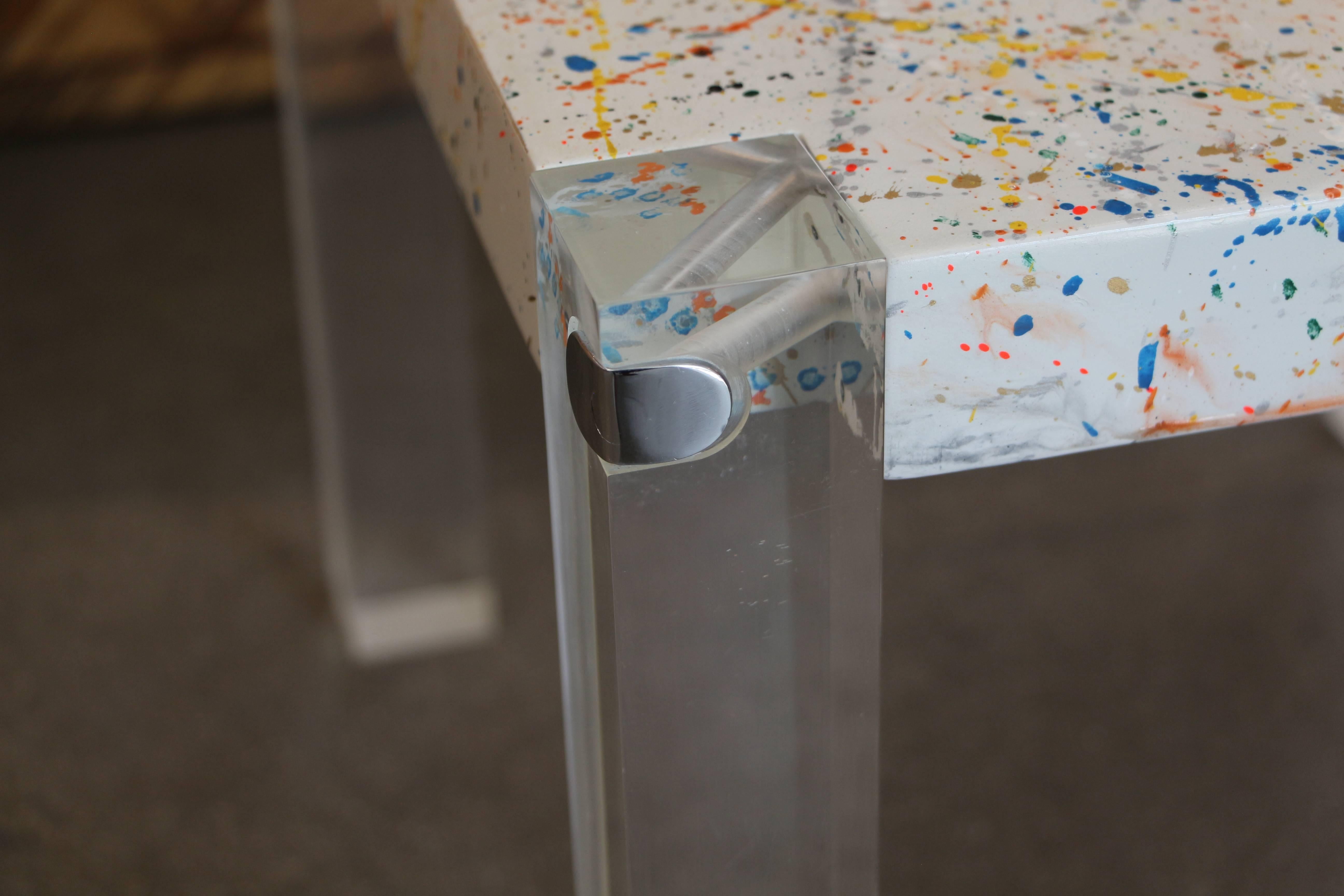 A cute table with Lucite legs and chrome accents, with a drip painted top inspired obviously by Jackson Pollack. Nice design. Top is newly artisan painted. The legs have been polished, although they still have some minor marks and scratches.