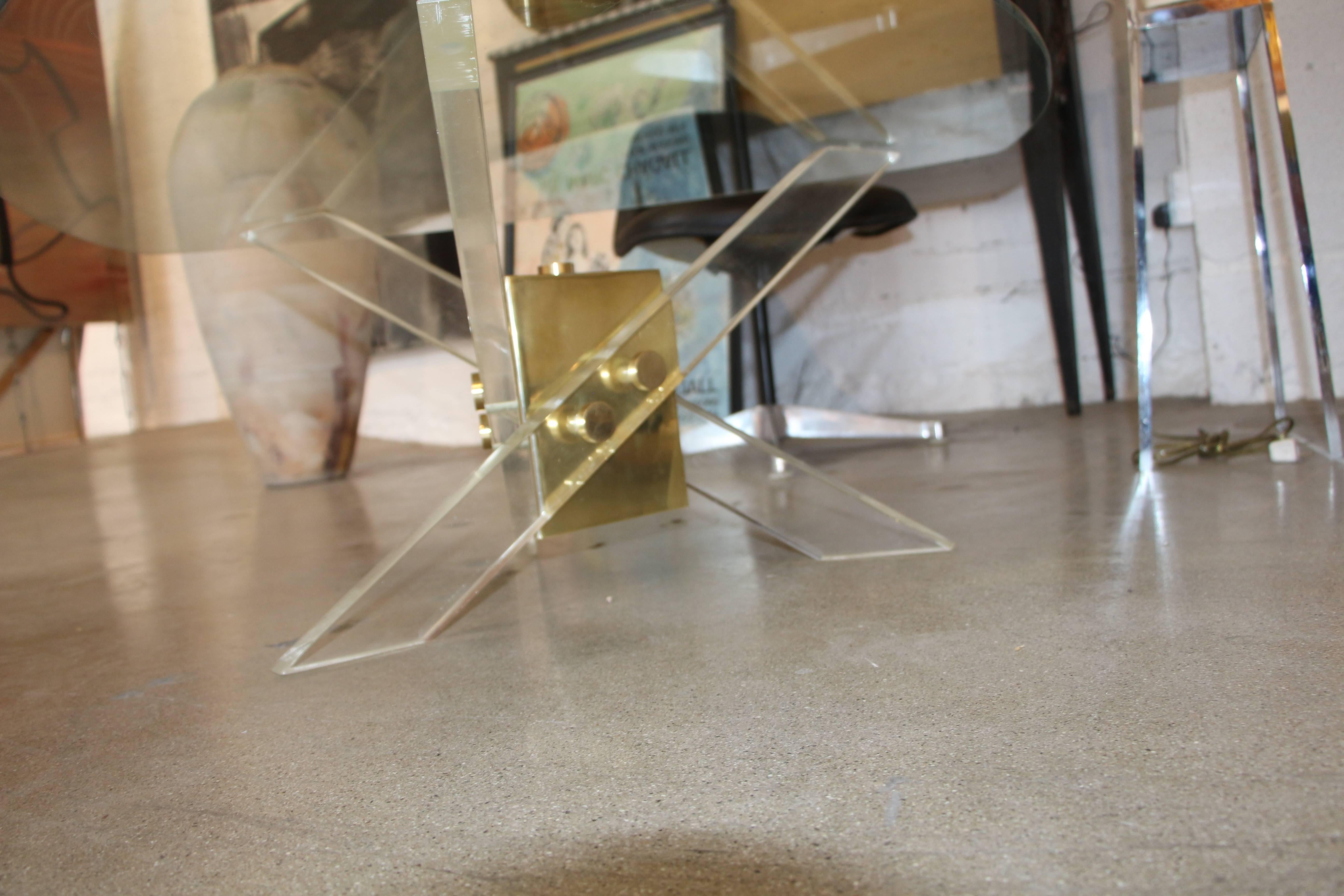 A nice table in the manner of a Pace Collection design. Nice Lucite legs with a triangular glass top. The glass top has scratches and the Lucite legs show some crazing and age appropriate nicks and scratches.