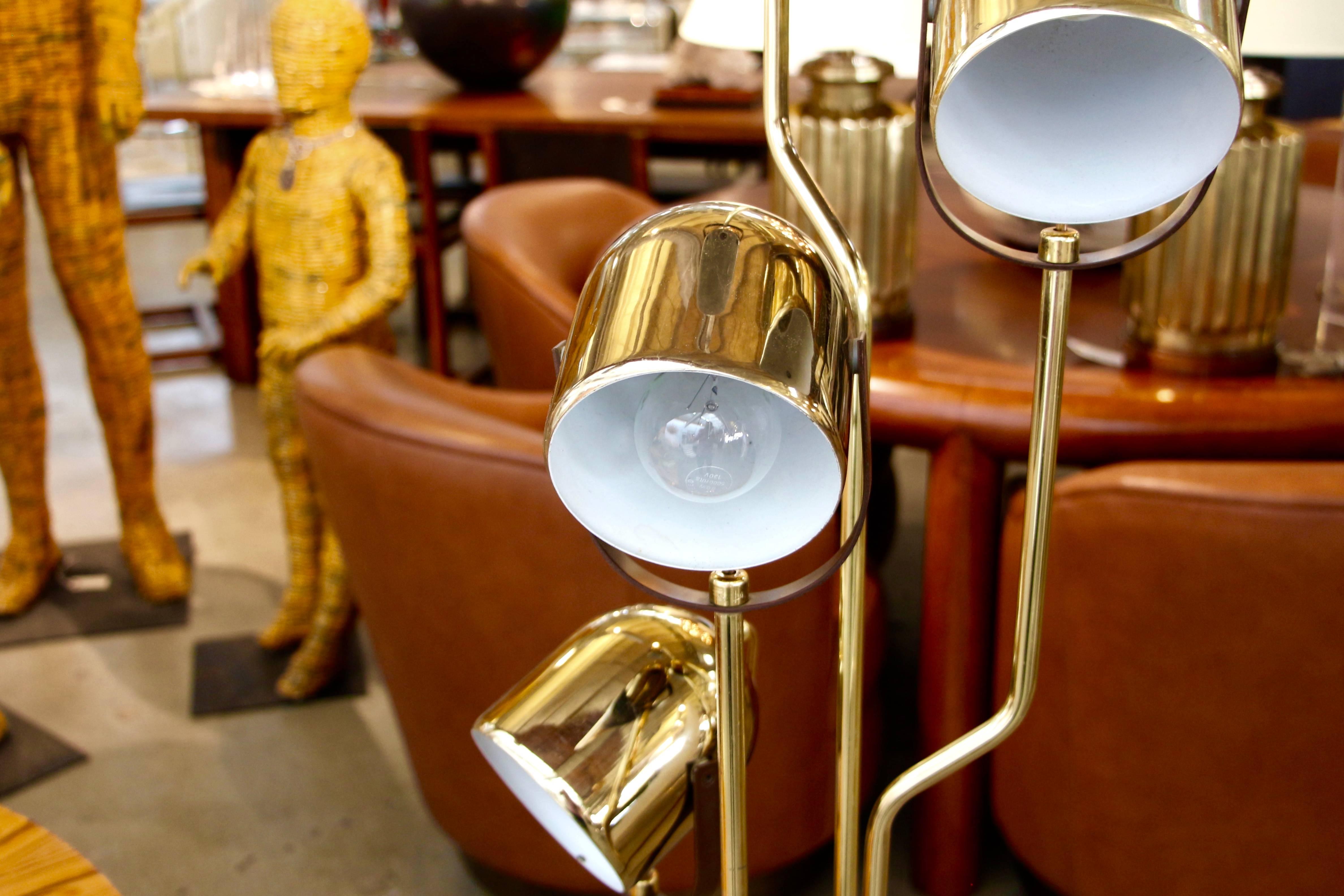 A nice vintage Reggiani floor lamp with four heads. It is brass-plated, and the bottom plate was worn. Please note that the brass plate on the bottom has been replaced with a solid brass place. It is slightly off square. There are numerous minor