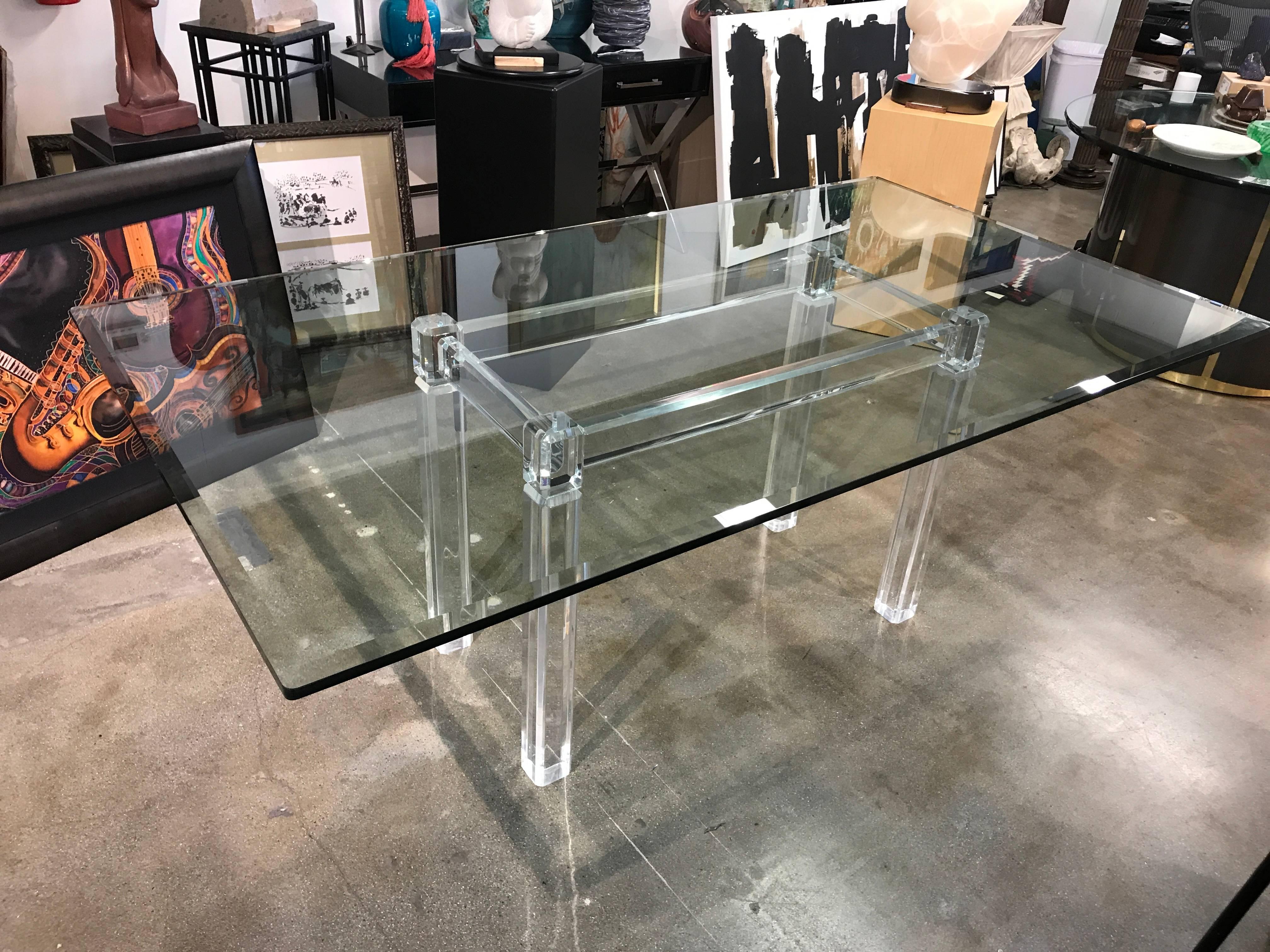 A really spectacular Lucite base dining table with a thick nicely beveled glass top. The Lucite is clear and free of color. Age appropriate wear with scuffing and minor marks, abrasions and surface scratches. An elegant design. Not signed.