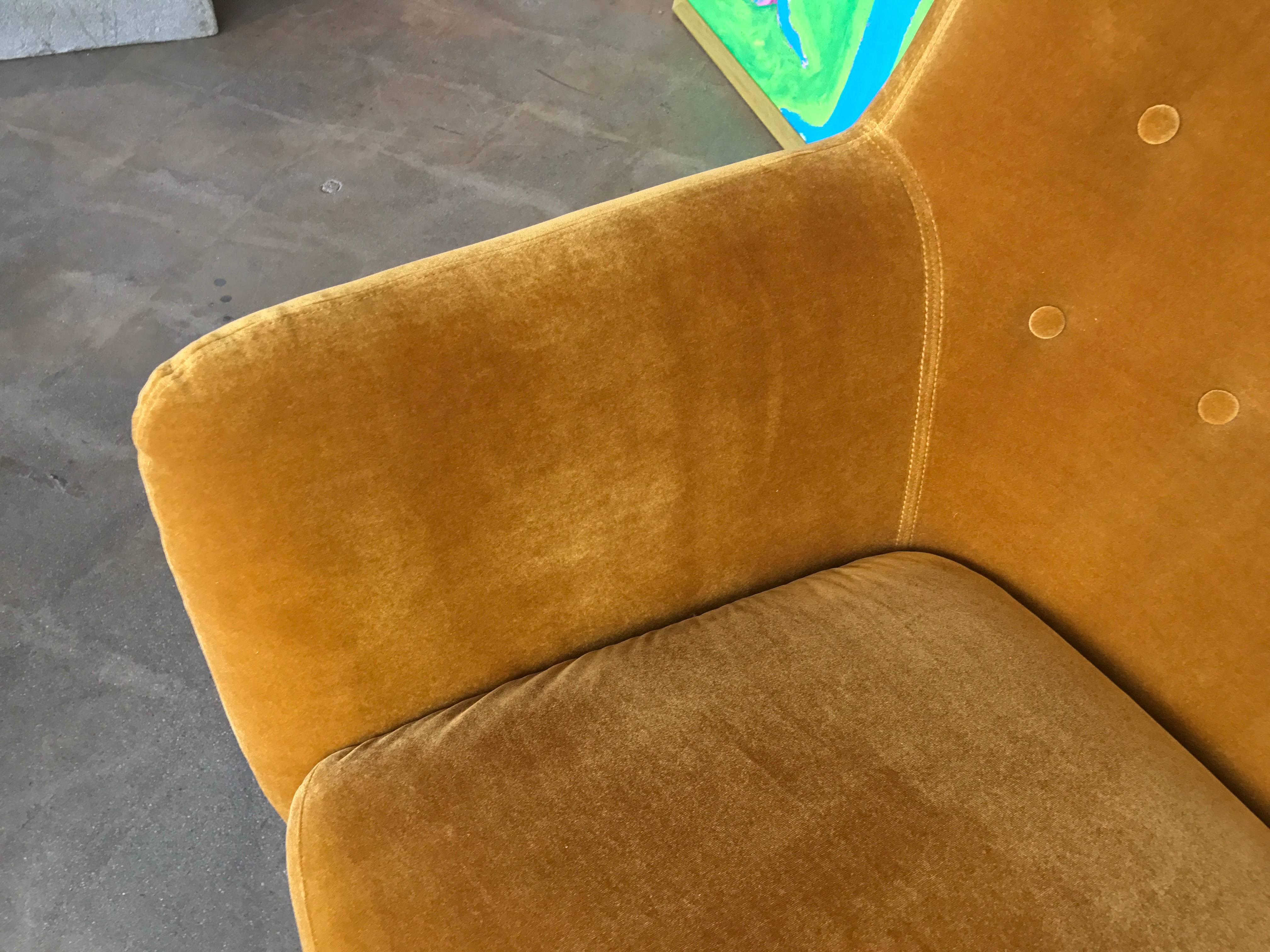 A sexy stylish curved sofa with a pretty color of yellow wool velvet upholstery. Cushions are attached to the sofa. The legs are oak. A extremely comfortable sofa. There are minor marks to the upholstery and legs. We have seen curved sofas like this