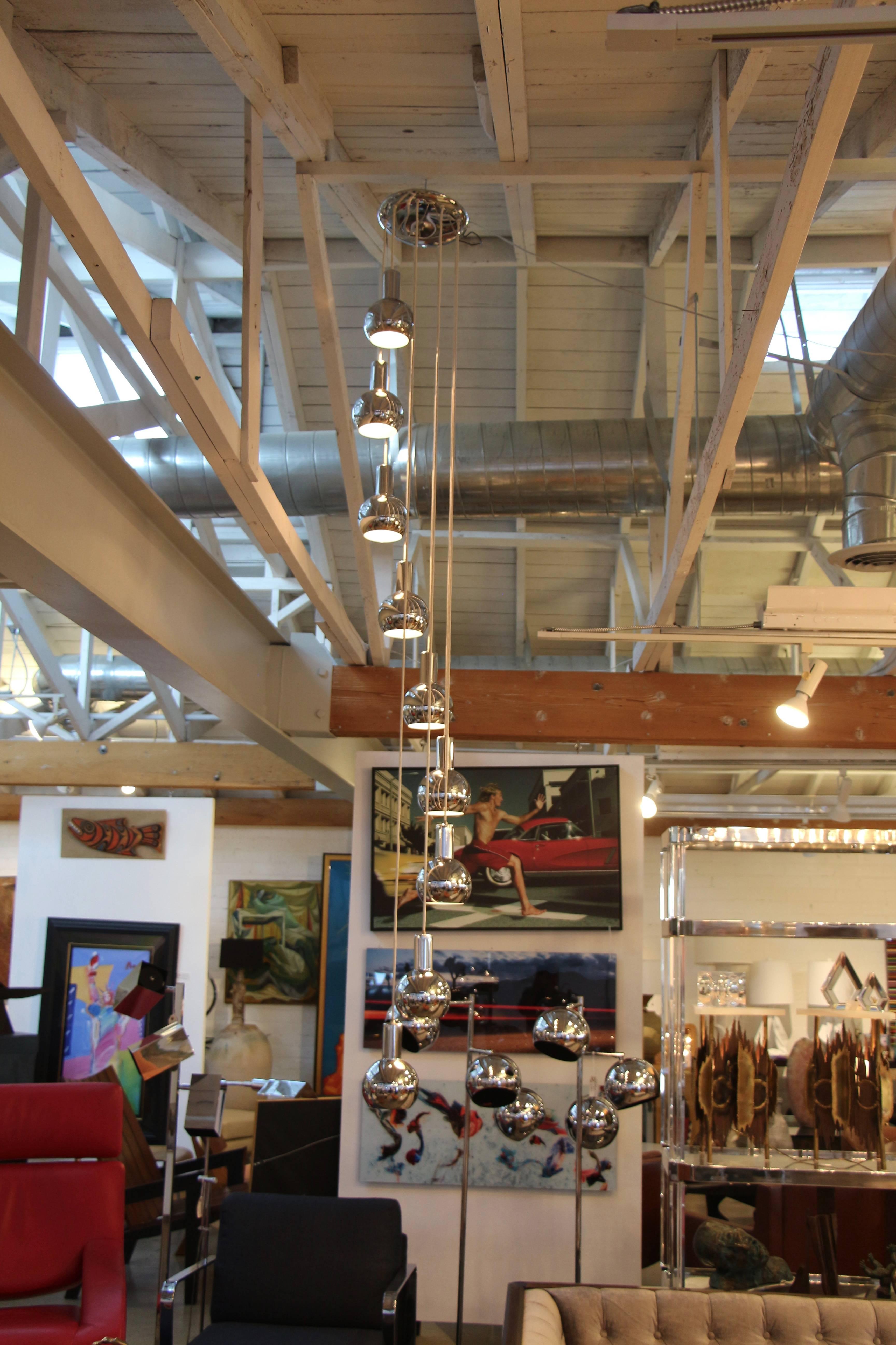 A rare chrome hanging pendant chandelier with nine cascading globes. We believe this fixture is from the 1970s. Some discoloration to the white cords and some marks to the chrome.