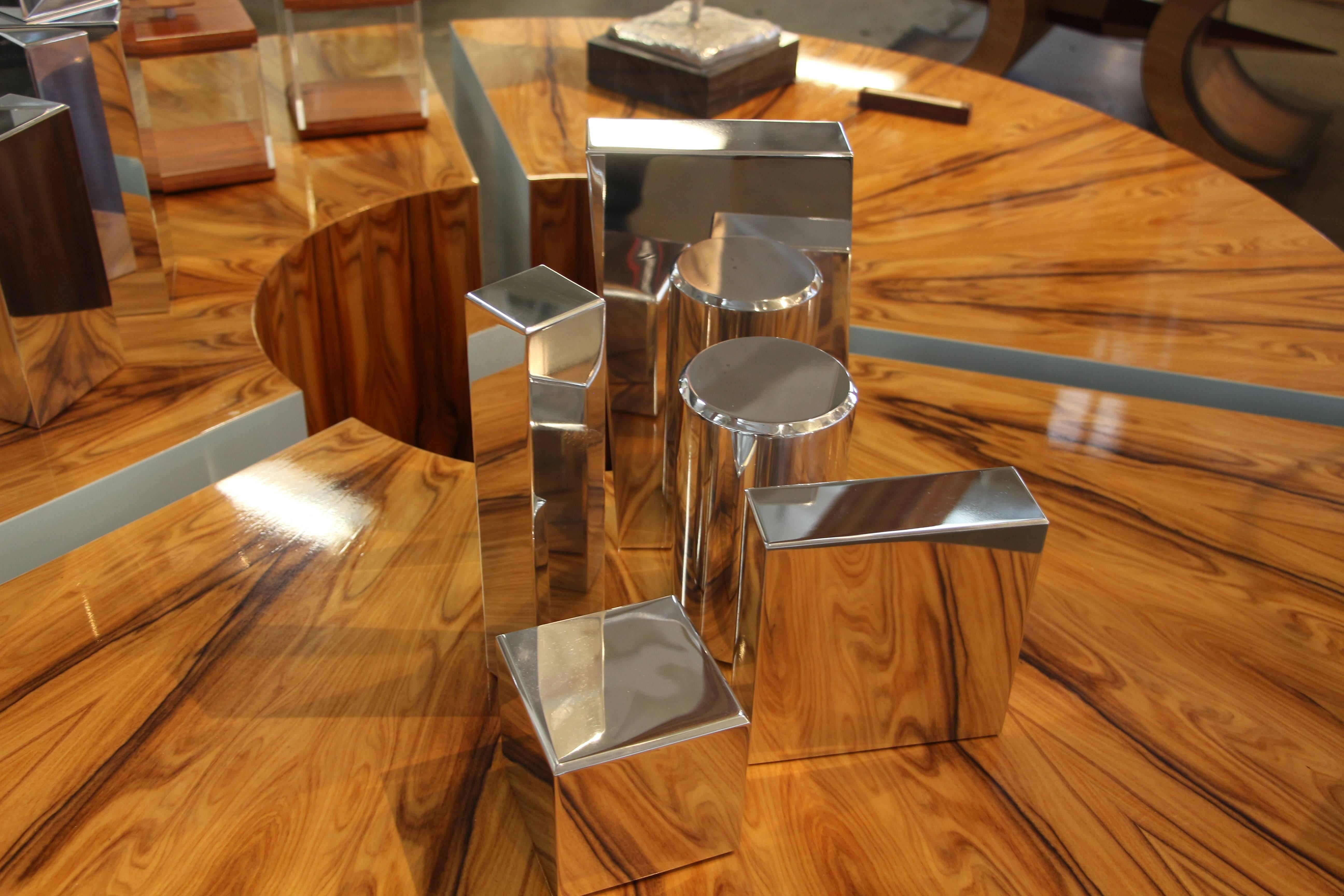 Our gallery is proud to represent an new talented artist Casey Cross who now resides in Palm Springs, CA. His work is unique and quite unusual. These geometric shapes can be arranged in any way. They are polished aluminium shapes. Each piece has