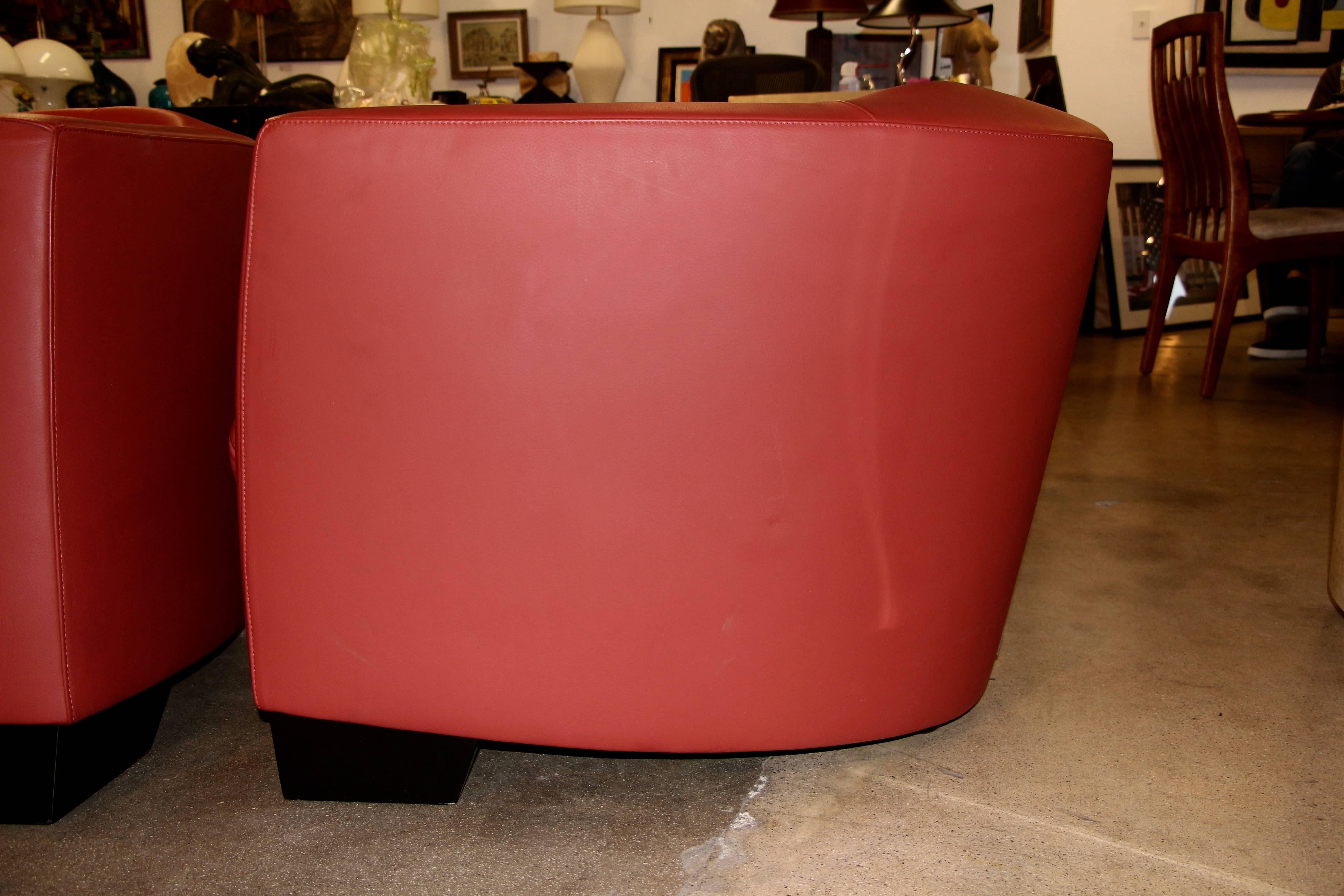 A sleek pair of red leather chairs by the design firm Team By Wellis of Switzerland. The bottom duvet bears their name, pictured. These chairs are as comfortable as they are elegant. In good condition, with some minor signs of wear, and minor