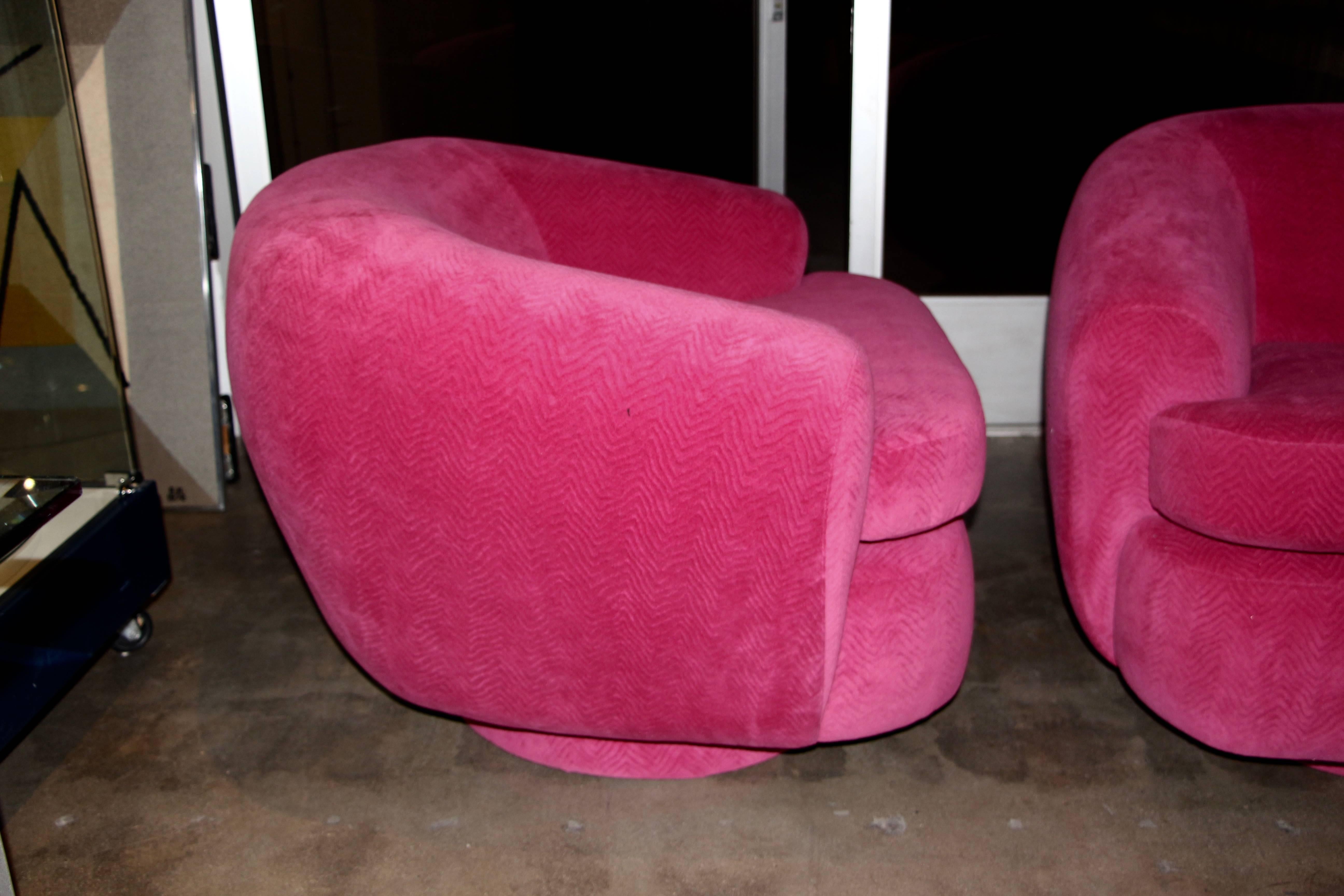 A wonderful pair of newly upholstered club or lounge chairs in a pink wool mohair. These chairs have been completely redone and are on upholstered swivel bases. Extremely comfortable and they make a great statement. These chairs have great
