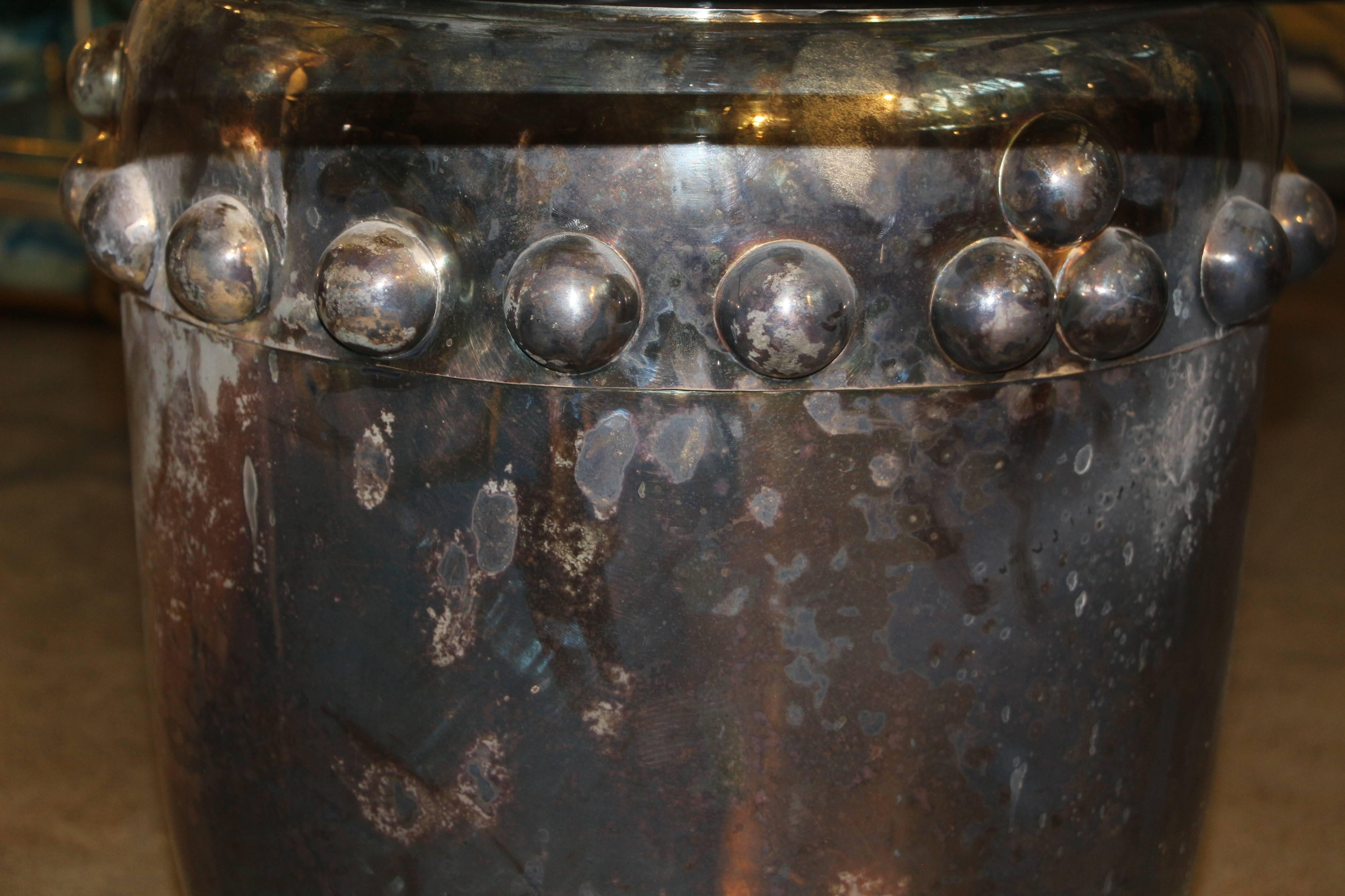 An nice silver plated Asian drum that has been made into a table by adding a 36 inch diameter piece of glass. The top is quite a bit dented and out of round. The base and top have silver loss and quite a few nicks, dent s and imperfections. These