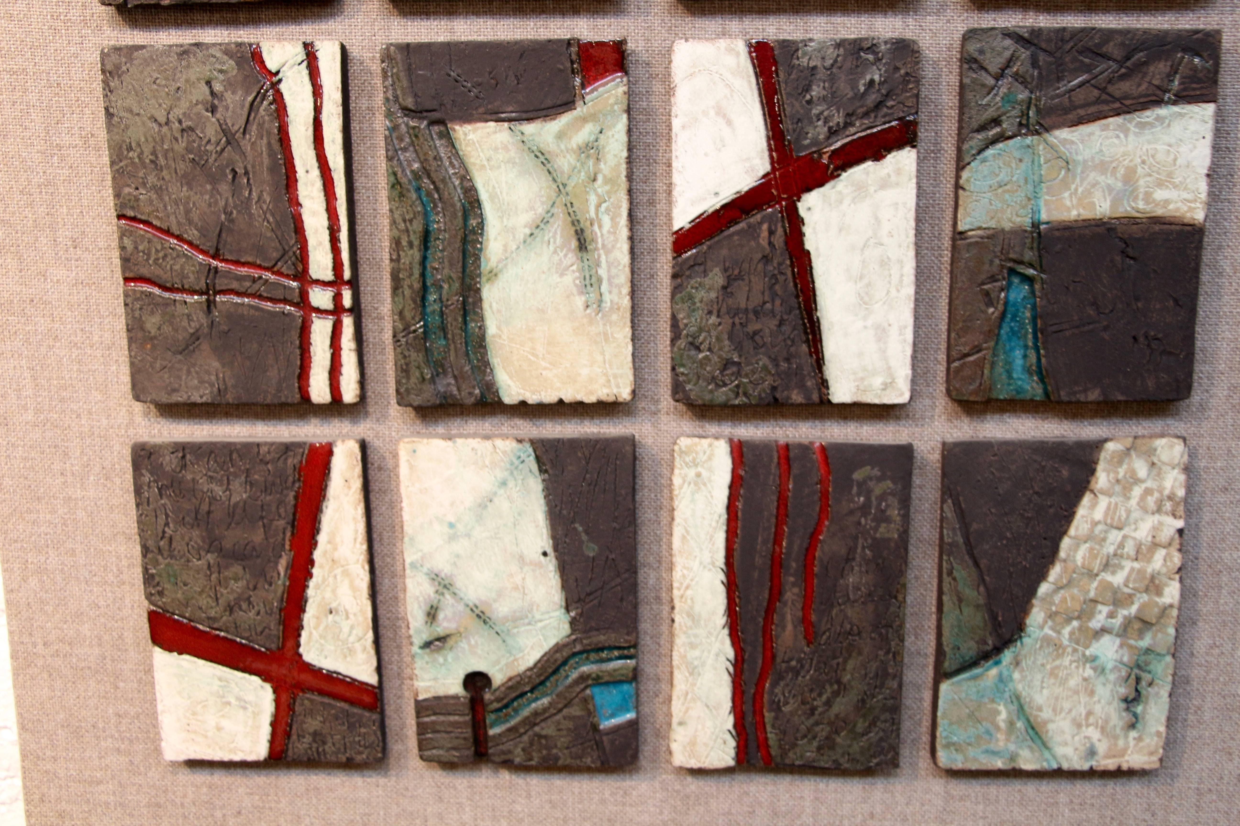 Une pièce d'art mural unique et inhabituelle. Il y a 20 carreaux montés individuellement, chacun unique monté sur un tissu semblable à du lin. Chaque carreau est une œuvre d'art en soi. Chacune mesure environ 6,5 pouces de haut et 4,5 pouces de