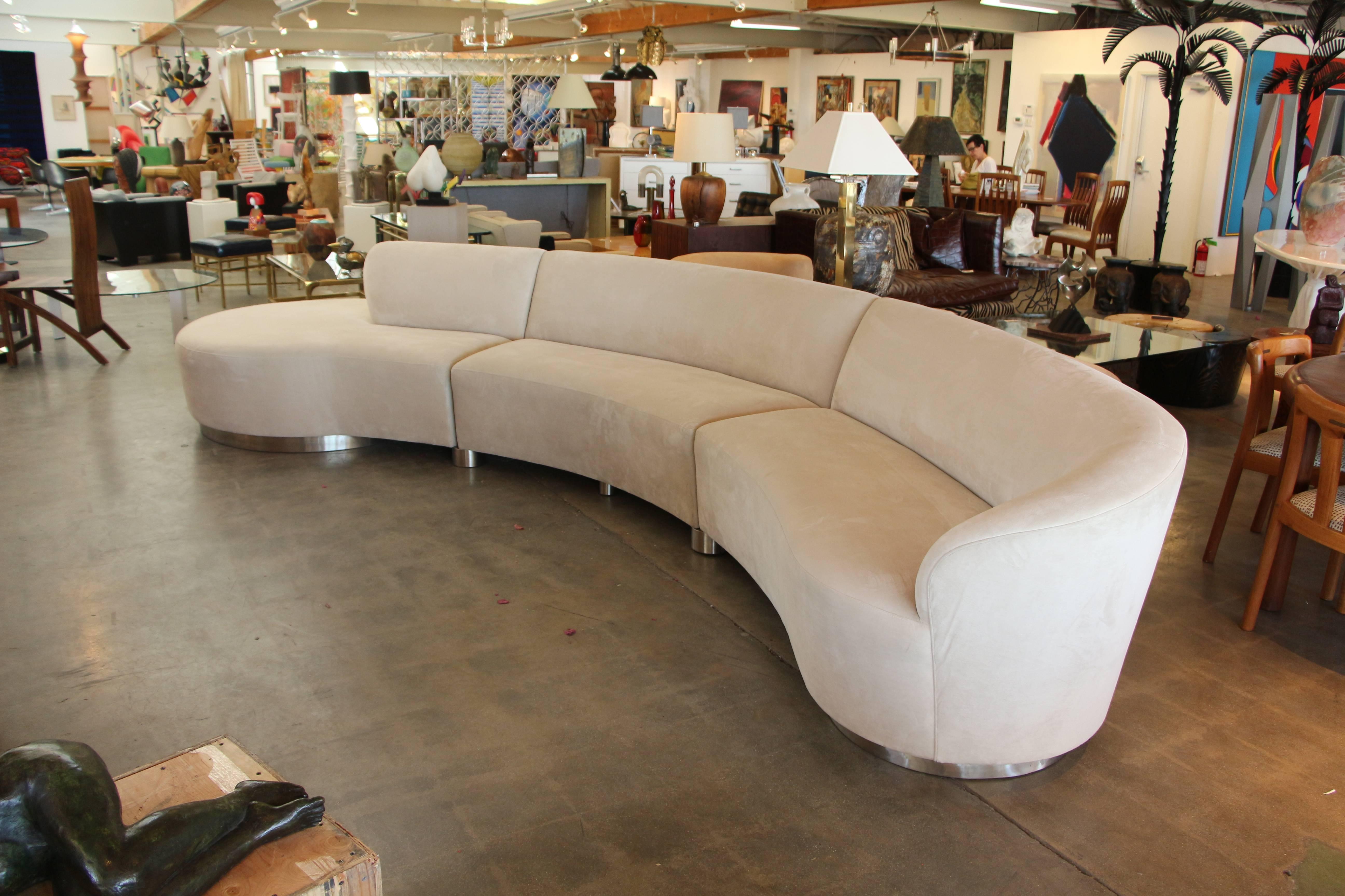 A monumental serpentine sectional sofa by Vladimir Kagan on brushed steel curved legs. Three sections with interlocking steel, pictured. Covered in a neutral Sand Ultra Suede. This sofa measures 15.5 feet from end to end. A lot longer along the