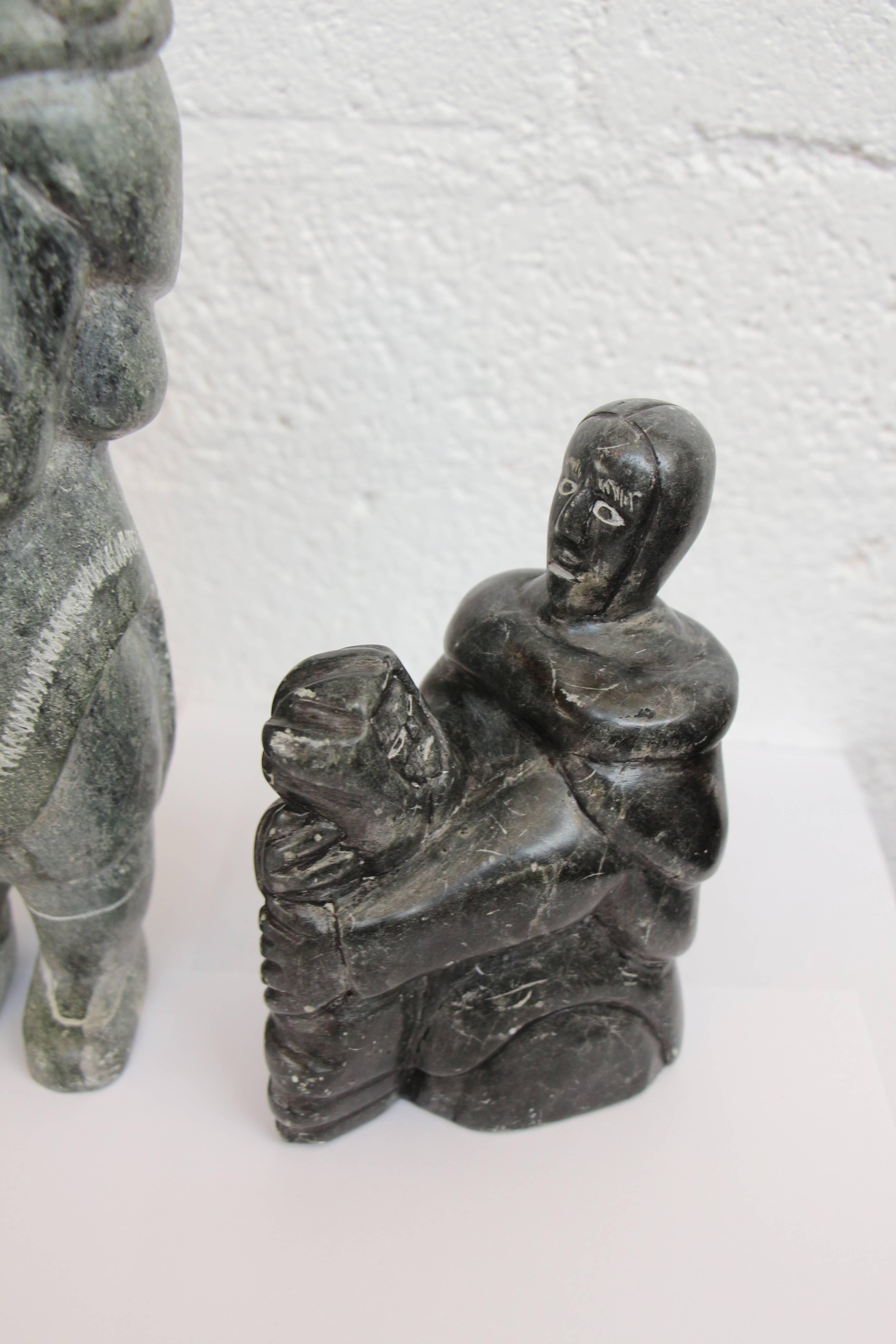 A lot of three inuit sculptures. The black one is signed and I have given up trying to decipher the carver. It also has the official Canadian sticker. This one is approximately 6 T x 4 W x 2.5 D. The next is a grayish looking carving of a mother