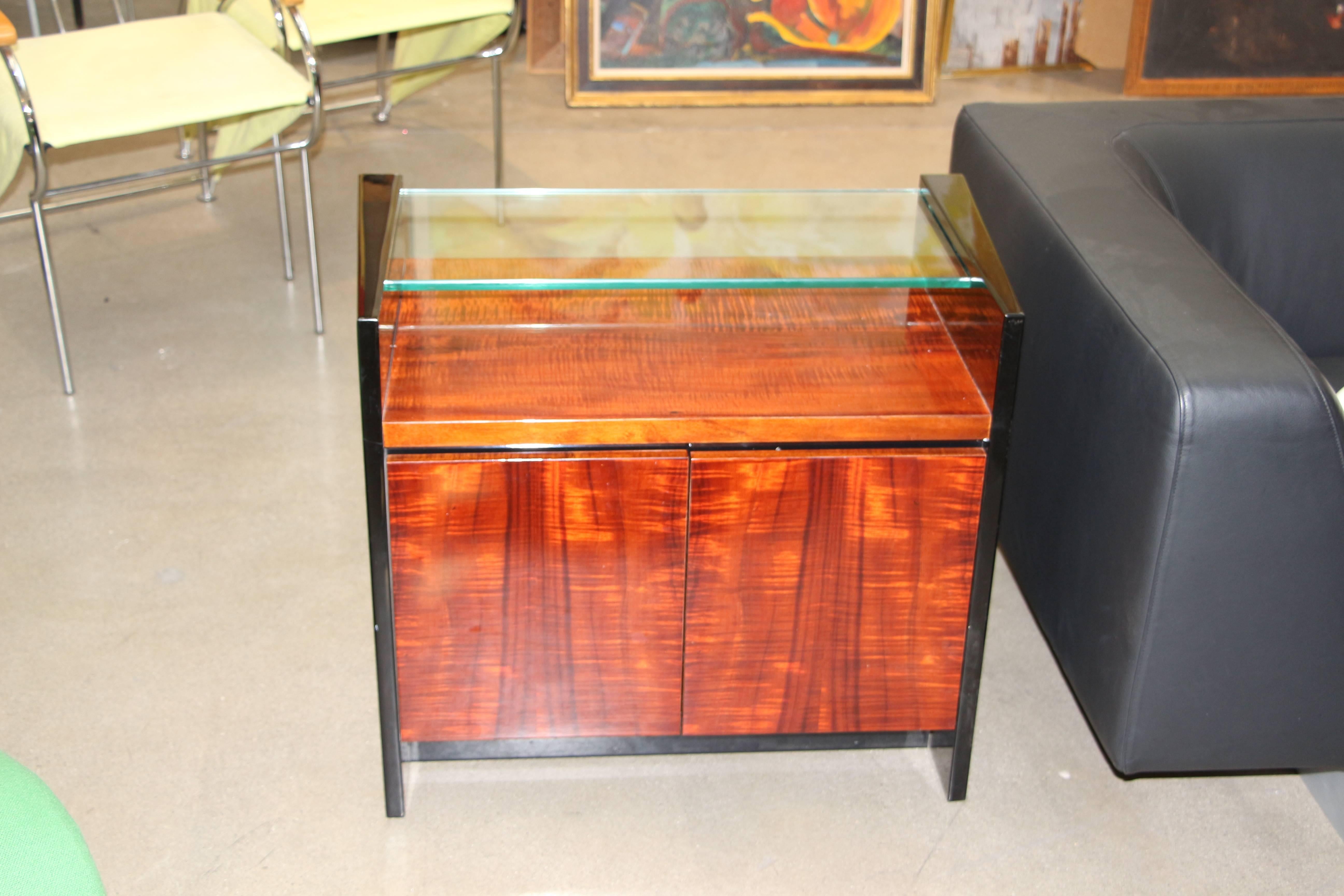 A beautiful pair of highly lacquered end tables or nightstands with beautifully grained wood. They look Italian to me. The glass tops slide in.