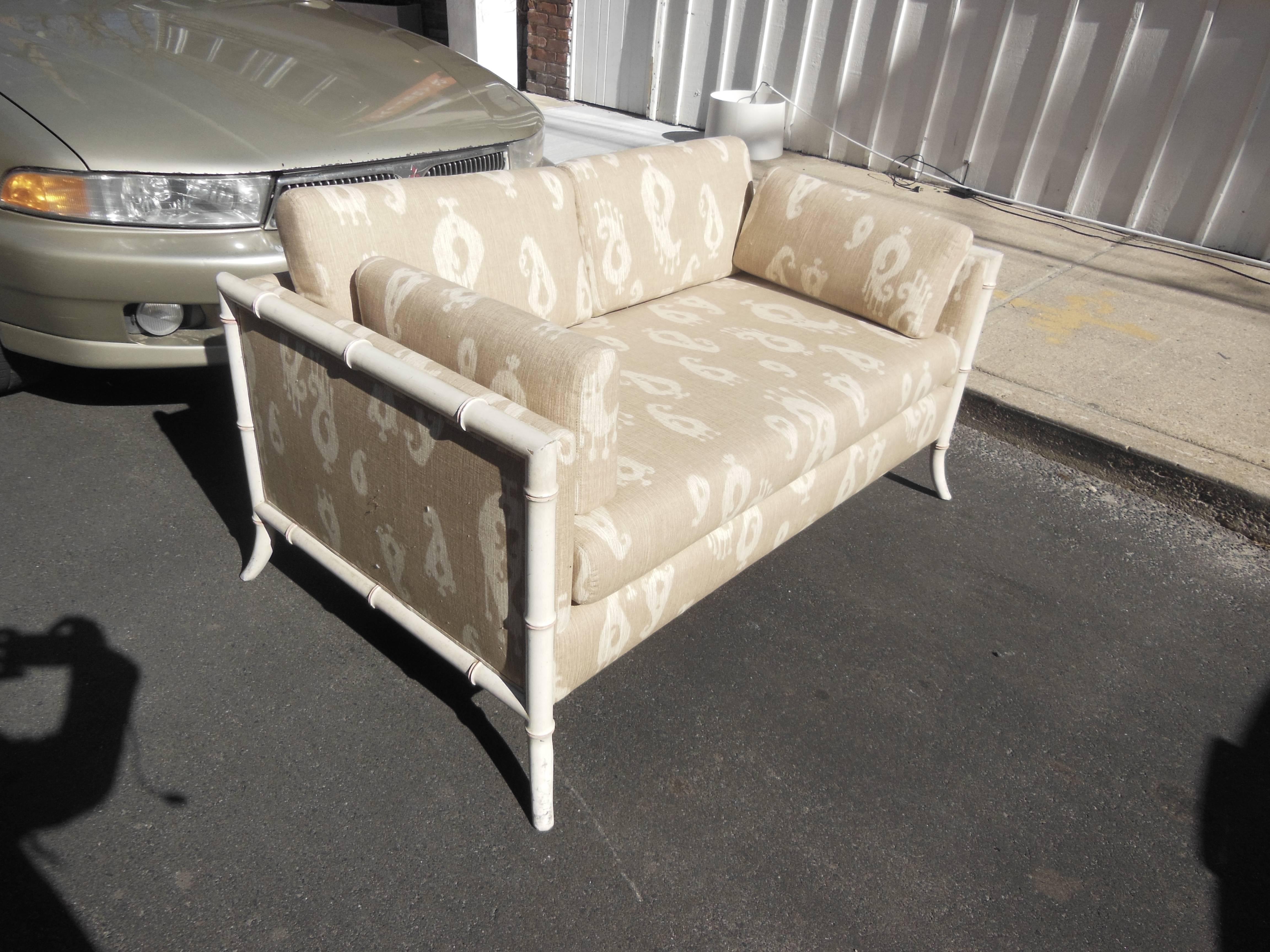 A vintage 1960s settee newly redone in cotton Ikat upholstery.