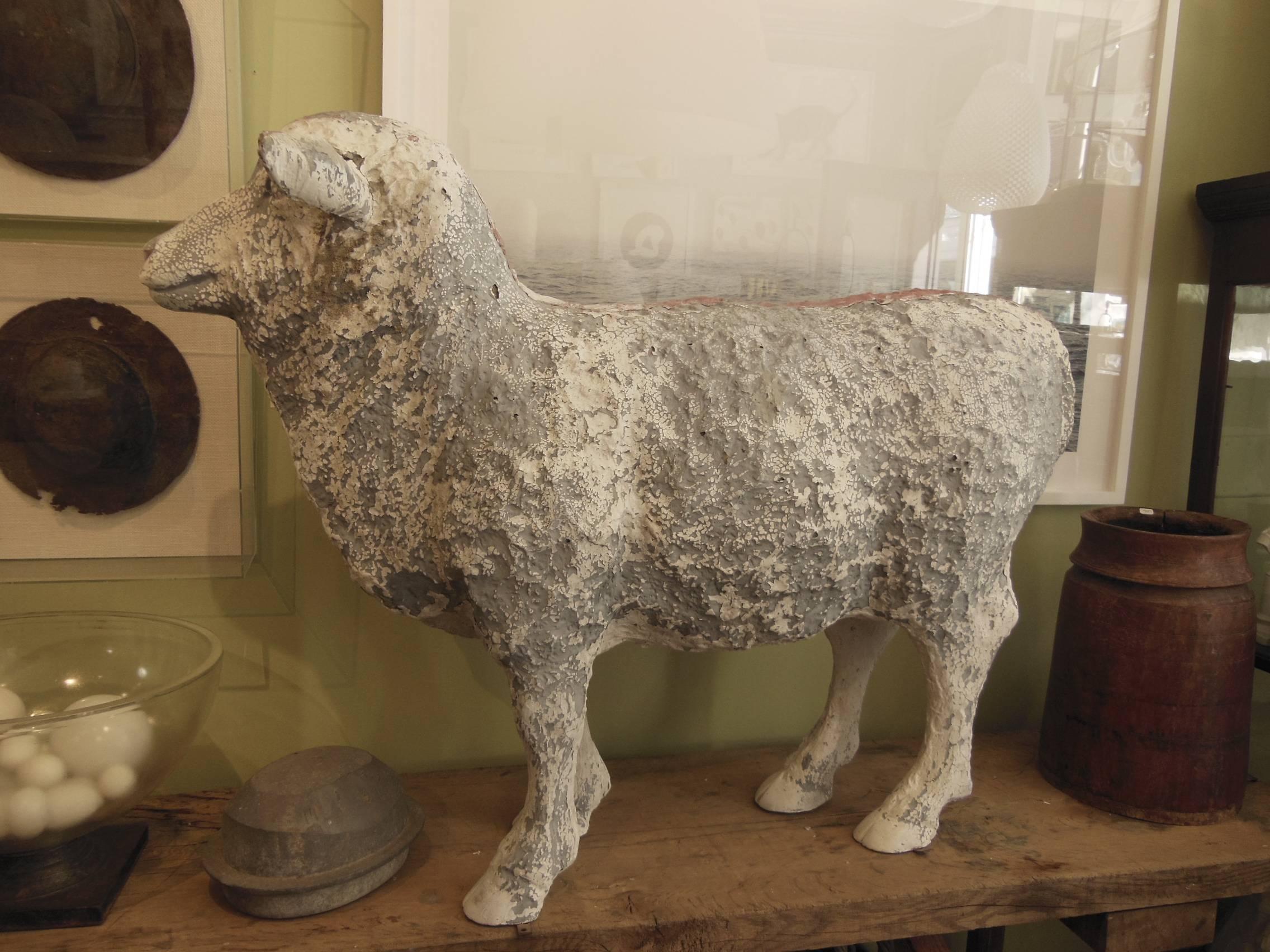 A vintage life-sized fiberglass sheep with faded paint.