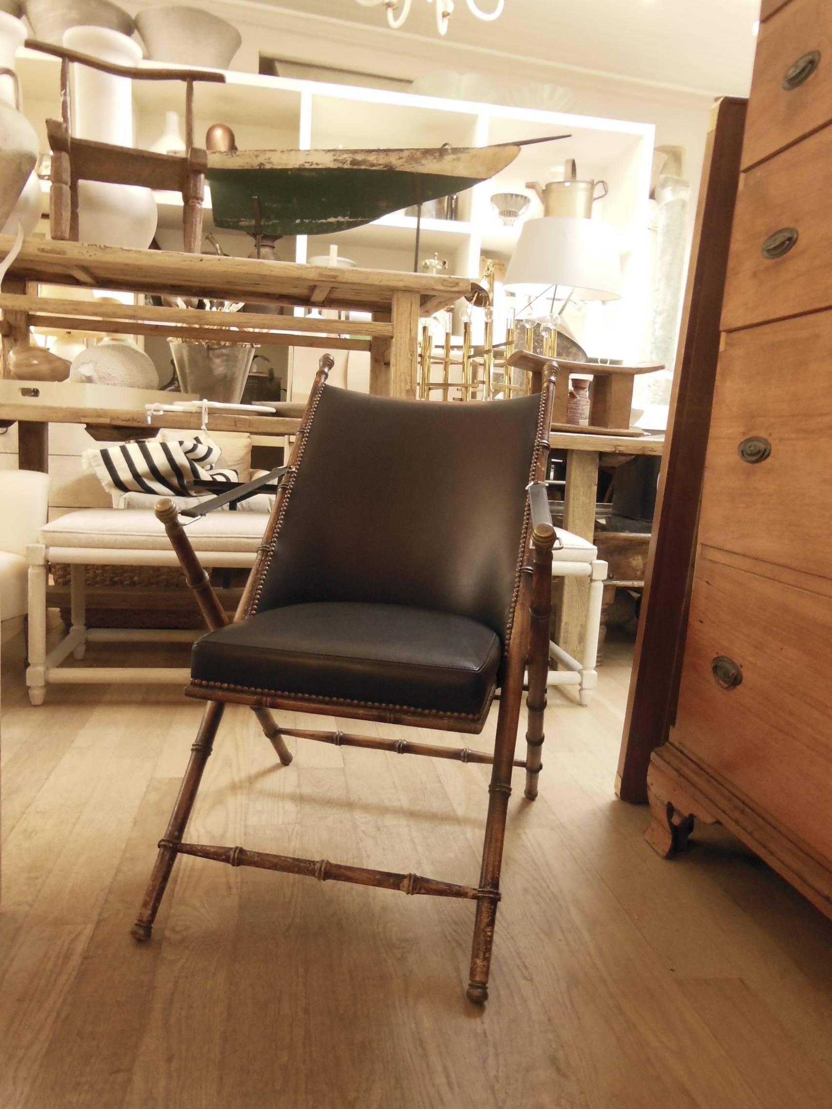 A newly redone in soft leather vintage Campaign chair with brass details, folds.