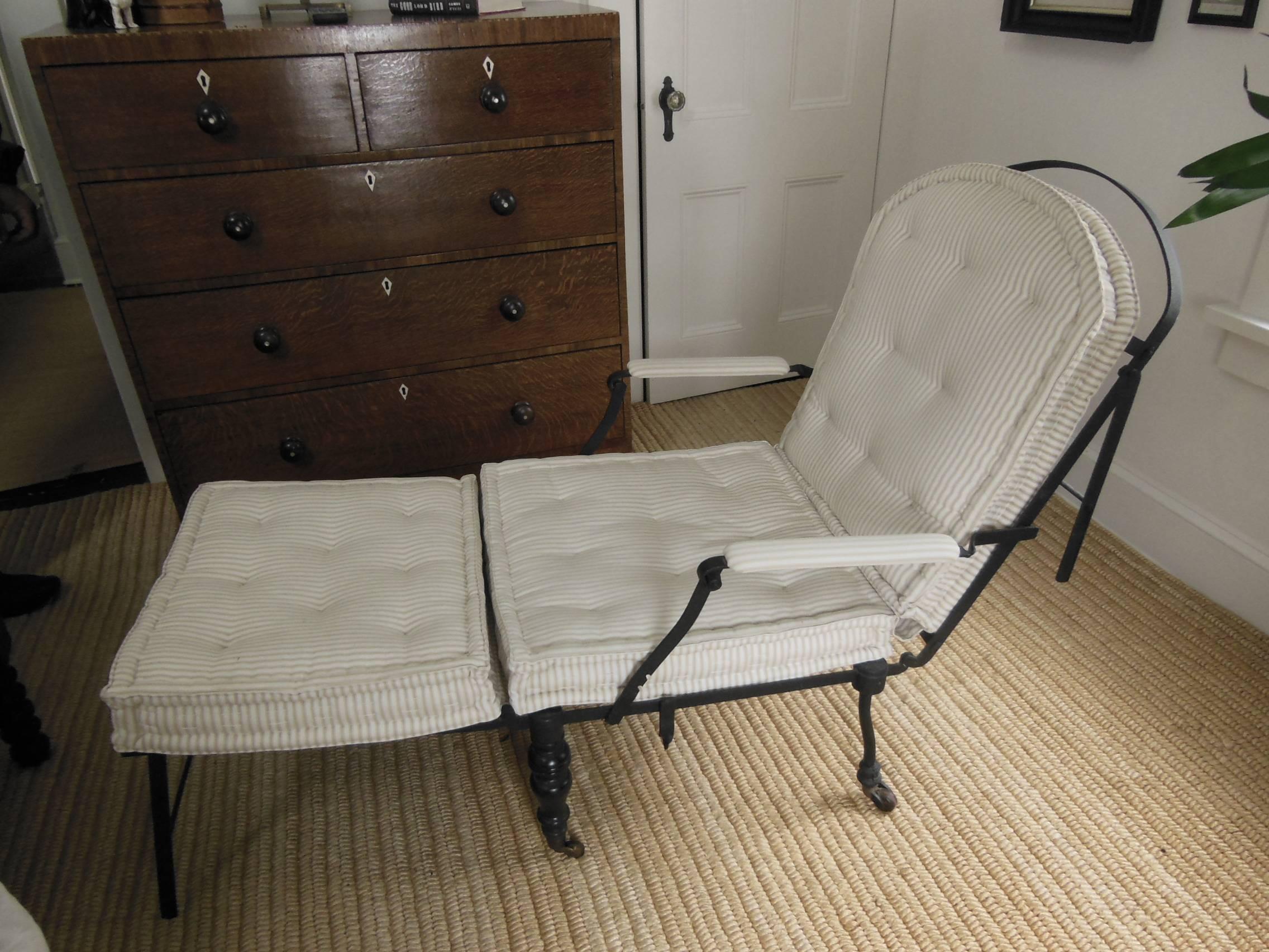 A great iron chaise that folds and adjusts with French rolled cushion in pale ticking.