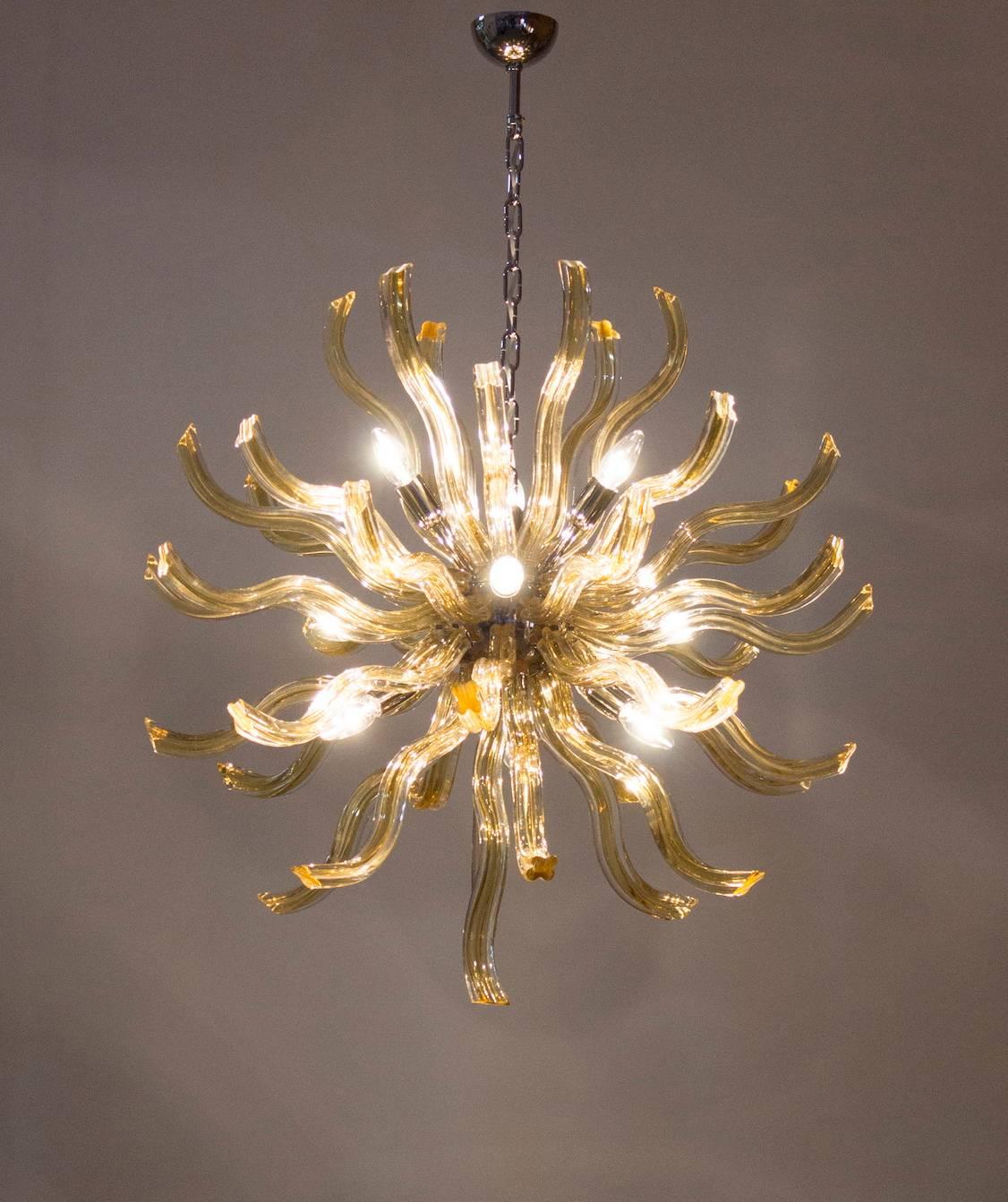 An Italian Mid-Century Sputnik with curvilinear transparent and gold toned Murano Quadriedro 1.25 inch thick rods which screw into a central orb with ten sockets newly wired for the American market suspended from a chain. Measures: 34