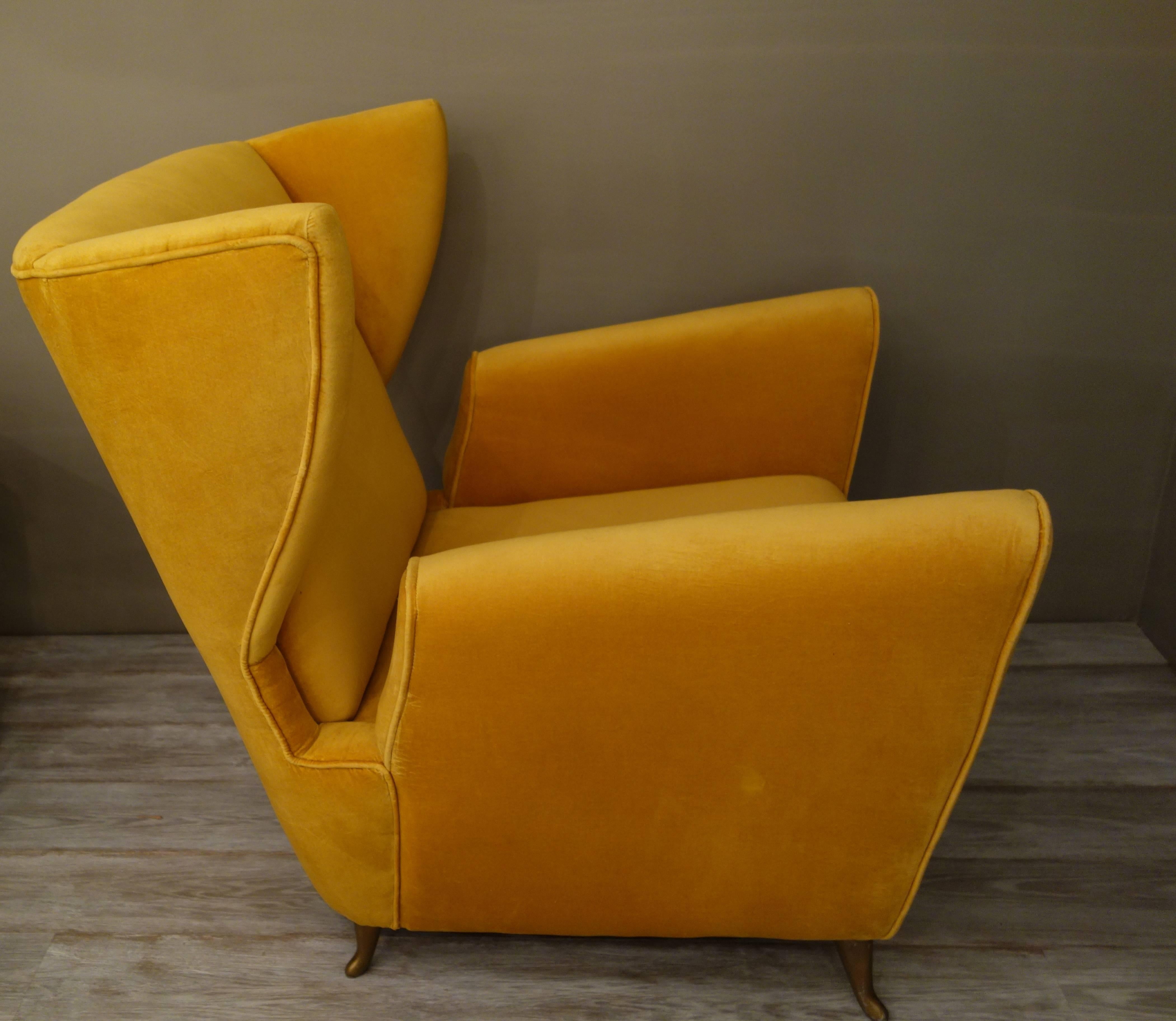 A pair of Mid-Century Italian lounge chairs or armchairs by Arredamenti ISA of generous proportions, the broad, curved, angled backs with deeply sculpted modified wings, the shaped, cutout sides forming the flared, slanted arms, with tight seats