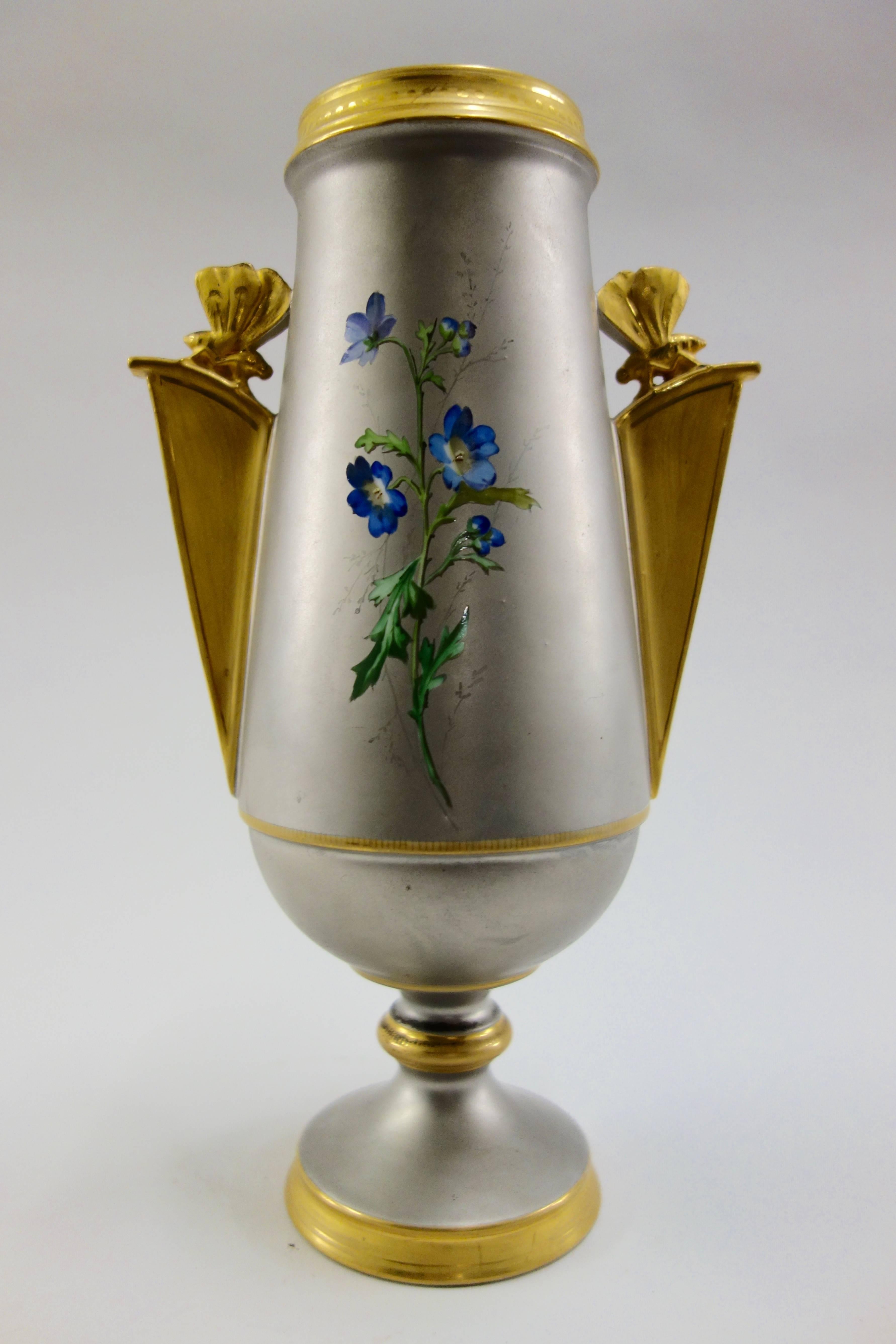 An Aesthetic Movement French enameled vase, circa 1880, the front with vividly colored, glossy, highly detailed flowers and leaves, the back with a single sprig of blue blooms attributed to Narcisse Vivien, known for his use of a platinum ground,