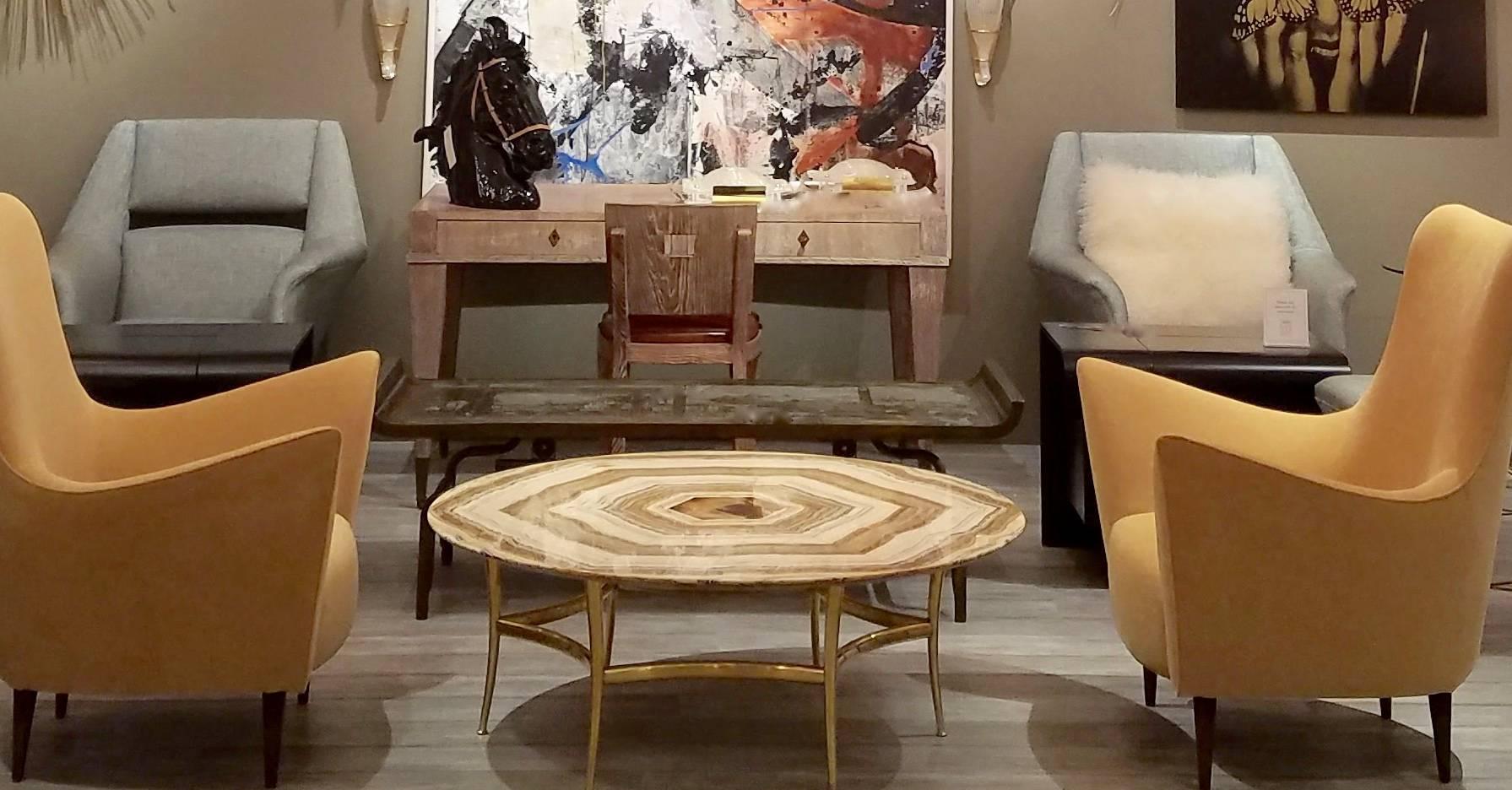 A Mid-Century Italian cocktail or coffee table, the circular top with bookmatched onyx in shades of cream, tan, charcoal and rust, the six sided pattern echoed by the hexagonal brass base with concave stretchers and slightly flared tapers legs,