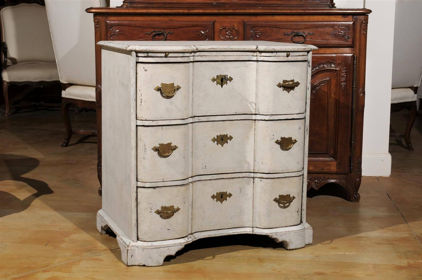 A Danish serpentine front three-drawer painted wood commode from the mid 18th century with pull-out shelf. This three-drawer commode was born in the 1760s in Denmark. Featuring a shaped top with beveled edges, a very thin pull-out drawer sits