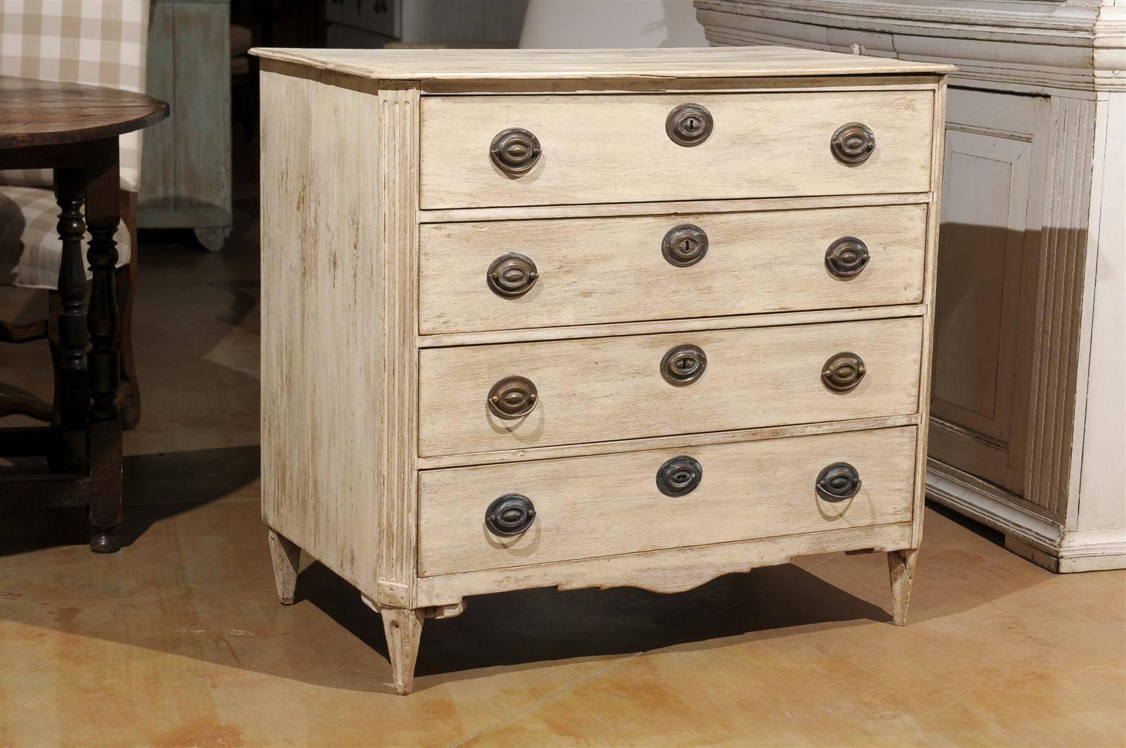 A Swedish period Gustavian four-drawer commode from the late 18th century with its old hardware. This Swedish chest circa 1780 features a rectangular top with chamfered sides in the front. Each drawer is adorned with oval escutcheons and handles. In