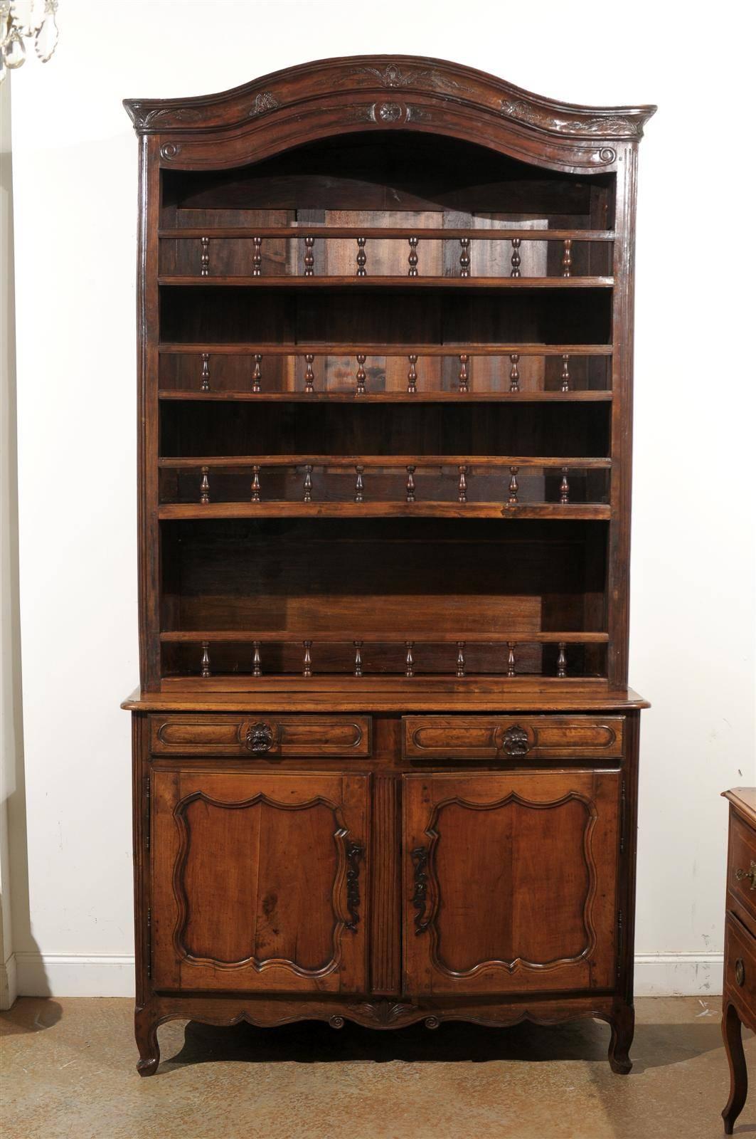A French late 18th century Louis XV style cherry two-part vaisselier with original hardware and open shelves over two drawers and two doors. This French buffet à deux-corps features a bonnet-shaped pediment carved with delicate foliage motifs,
