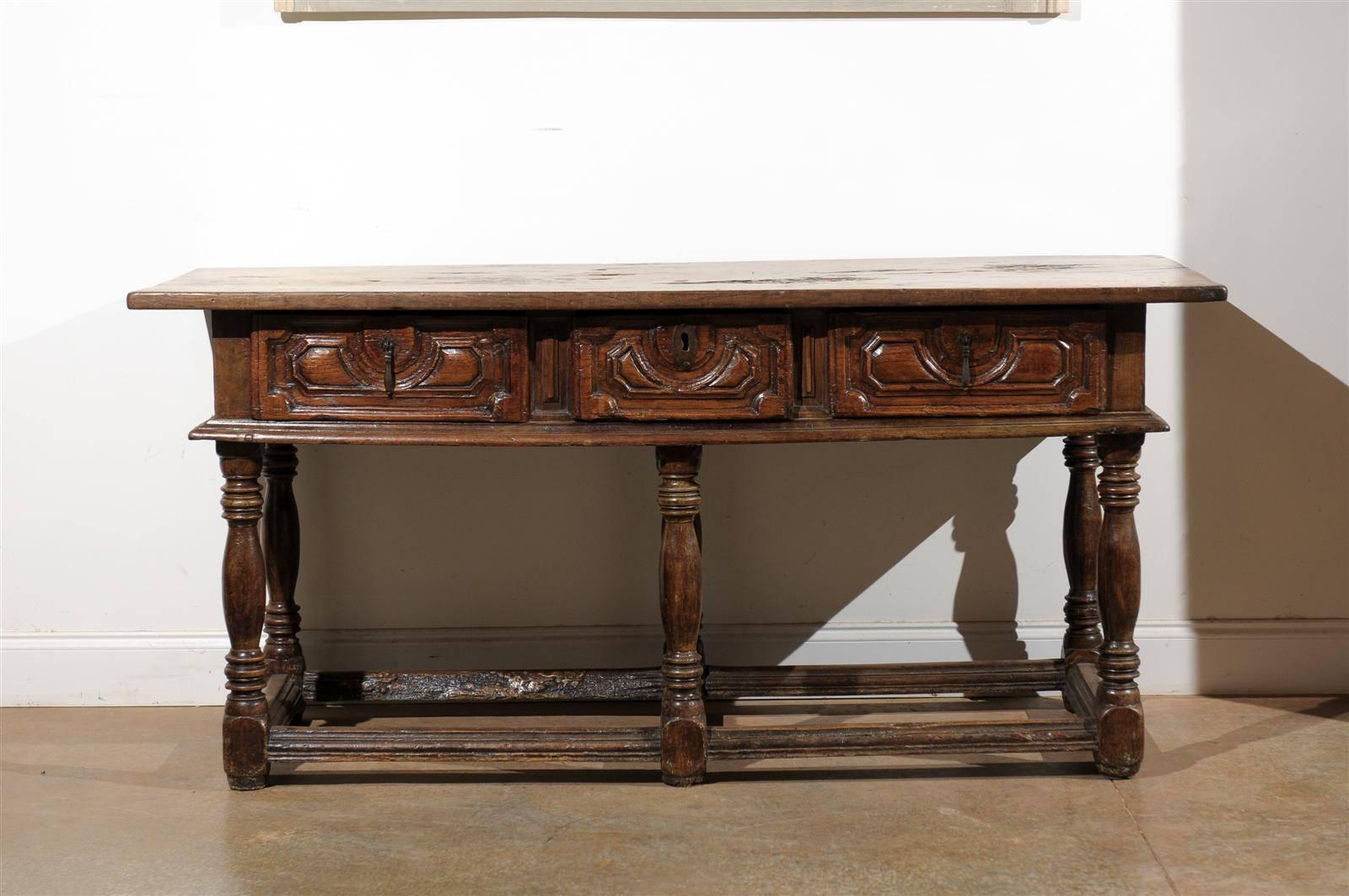 Spanish 17th century Spanish console or sofa table with three drawers. Carved apron on all four sides. Original hand-forged hardware, circa 1650.