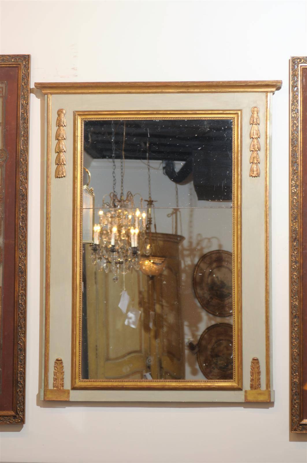 A French late 18th century period Directoire painted and gilded trumeau mirror with original split mercury glass, campanula and waterleaves. This French trumeau mirror features a clean profile, typical of the Directoire period. Painted in a light