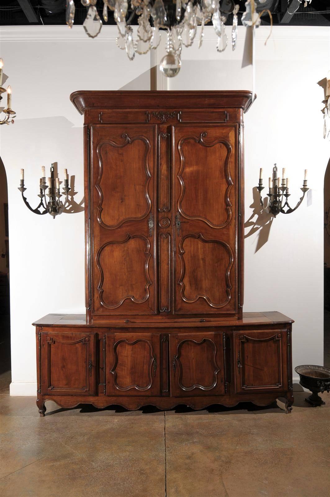 A French Louis XV period cherry buffet à deux-corps cabinet with original hand wrought-iron hardware from the mid 18th century. This French tall cabinet, which comes from an important manor house, features a lower cabinet, made of a four-door