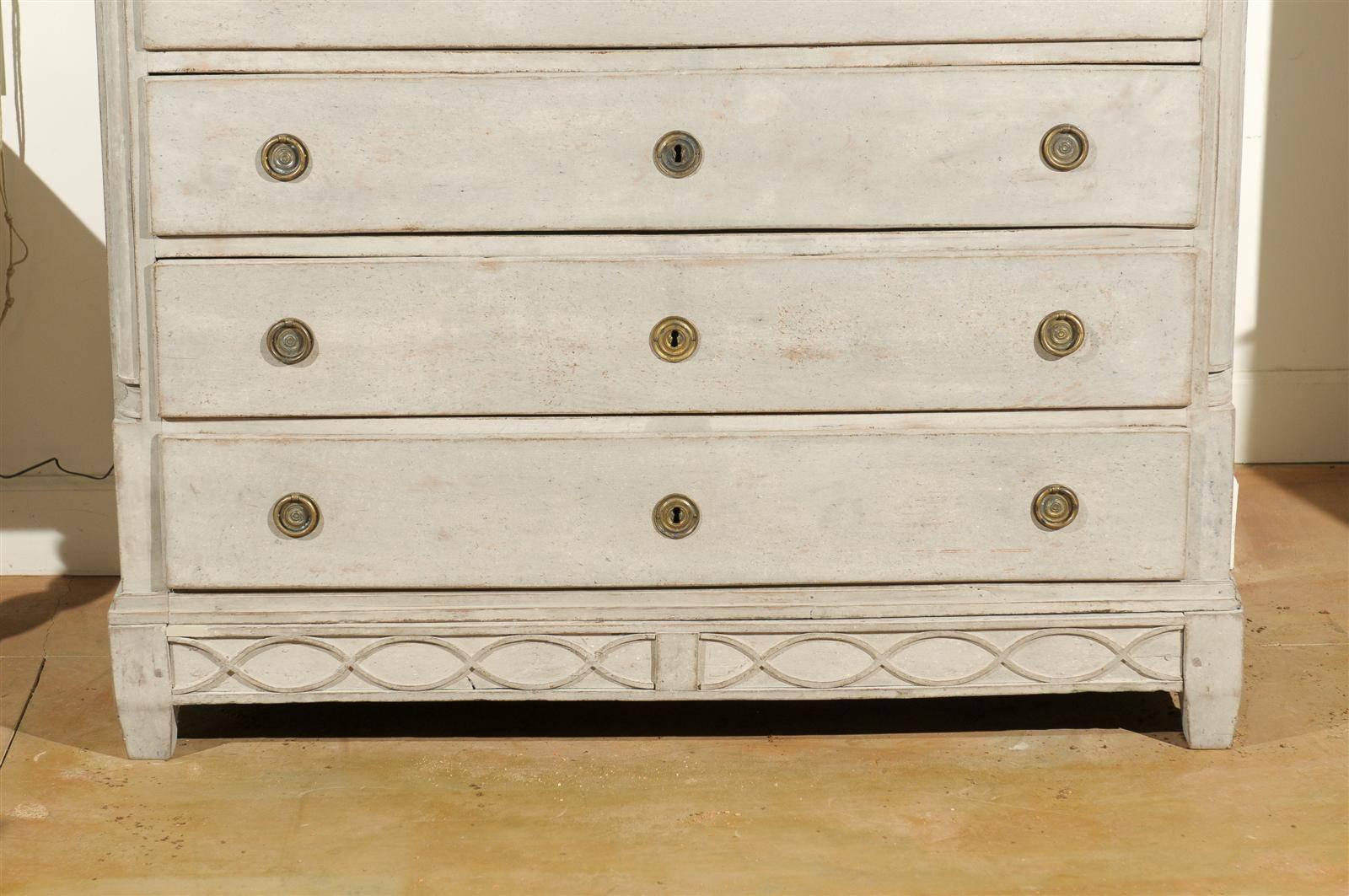 A Swedish Neoclassical painted wood five-drawer commode with swag décor from the early 19th century. This Swedish painted chest features a rectangular top sitting above a narrow frieze drawer followed by four larger dovetailed ones. If it weren't