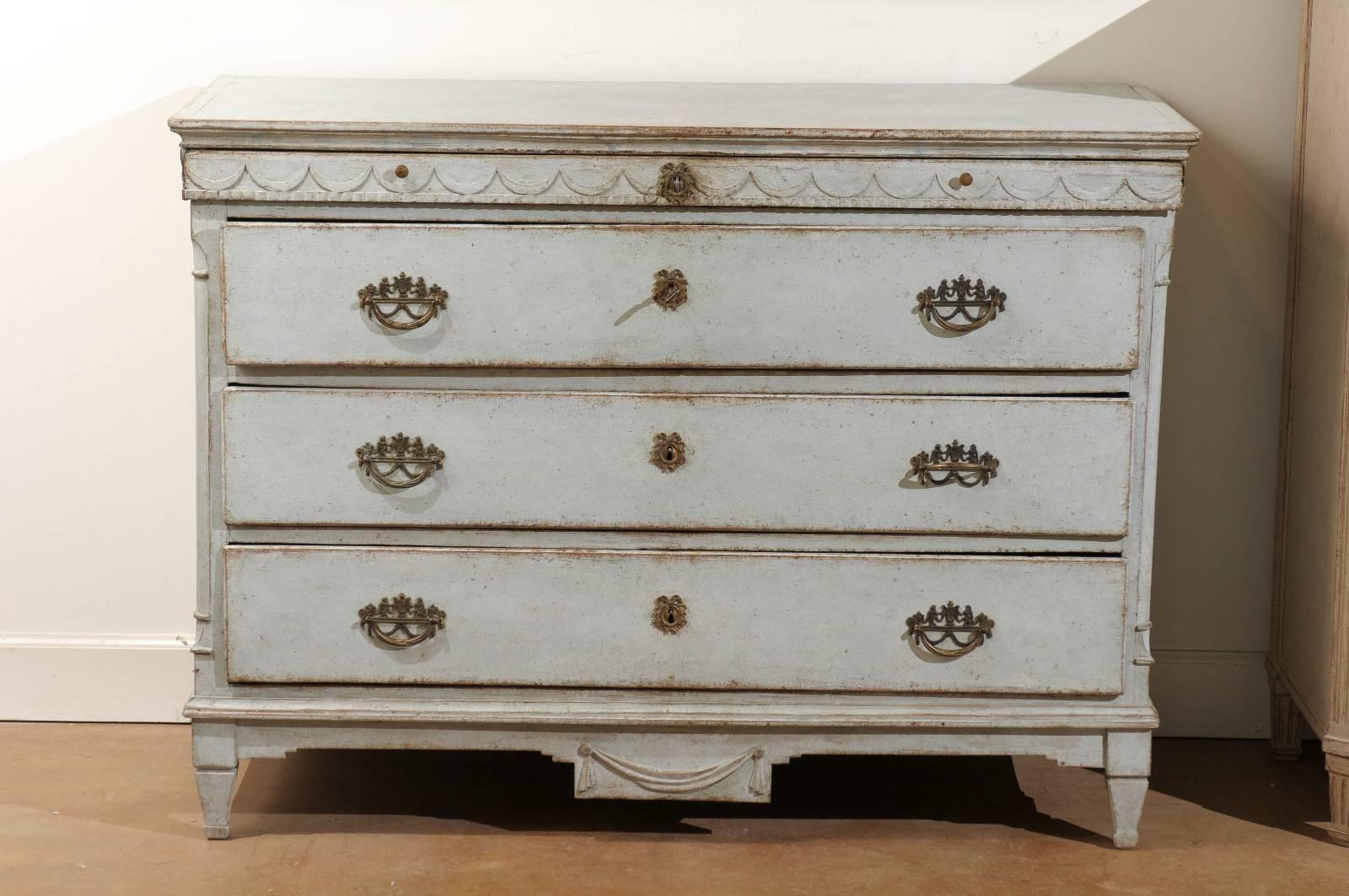 A Swedish Neoclassical painted commode from the early 19th century with original paint and hardware. This Swedish painted commode features a rectangular top sitting above a small upper drawer and three larger ones placed below. Painted in its