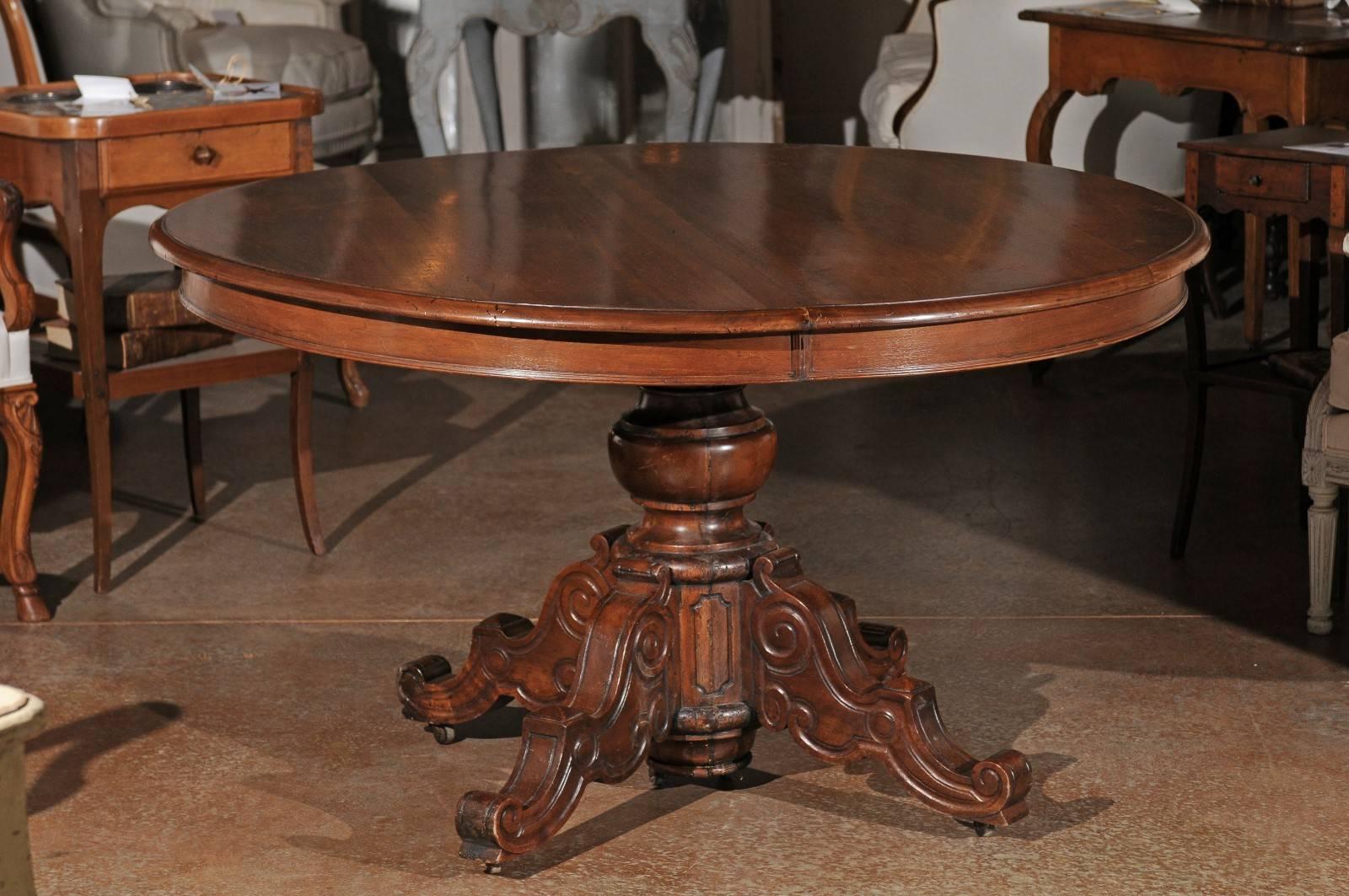 A French Napoleon III round walnut pedestal table with carved base from the mid 19th century. This French table was born in the 1850s, at a time when the first French president, known as Louis Napoléon Bonaparte was about to become Emperor Napoleon