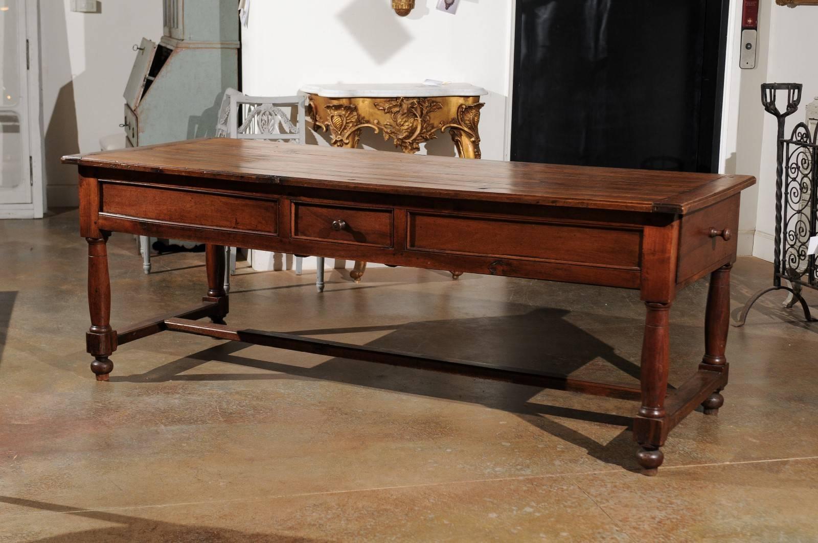 A French walnut and acacia wood sofa table with four drawers, turned legs and cross stretcher from the late 18th century. Born in the later years of King Louis XVI's reign, this French sofa table features a rectangular planked top sitting above an