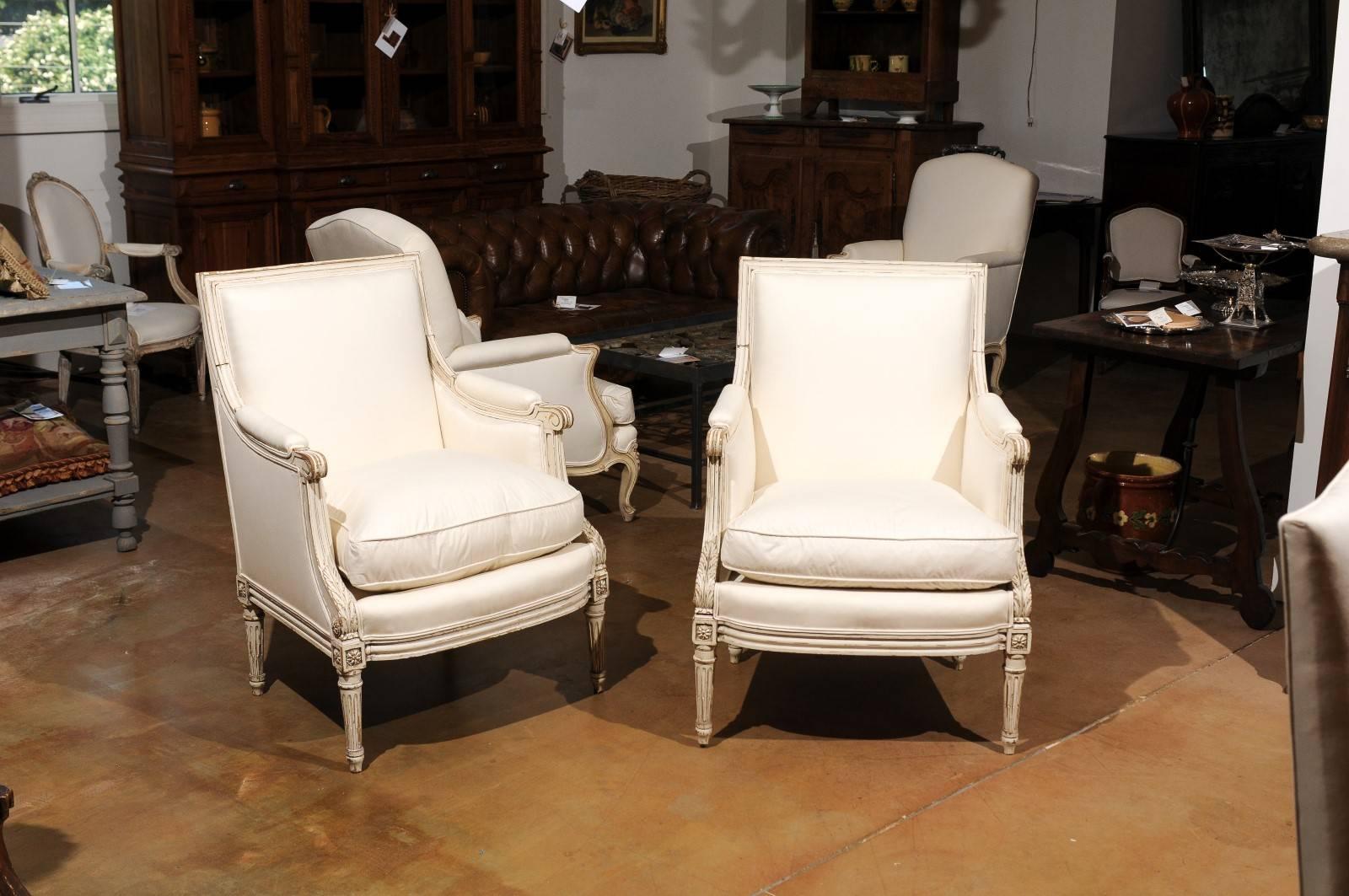 Carved Pair of French Louis XVI Style 1910s Bergère Chairs with Light Painted Finish