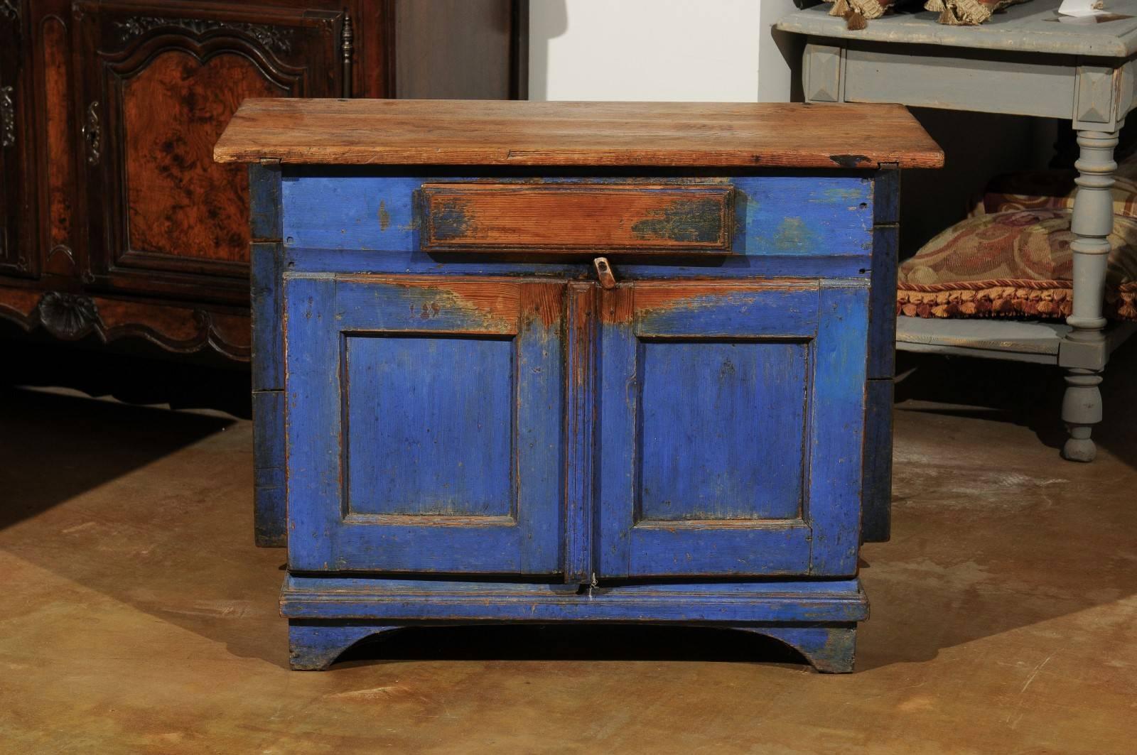 A Swedish blue painted buffet with attached drop-leaf table from the mid 19th century. This uncommon Swedish buffet features a two-plank rectangular top sitting above a single drawer and two doors painted in their original blue color. The nicely