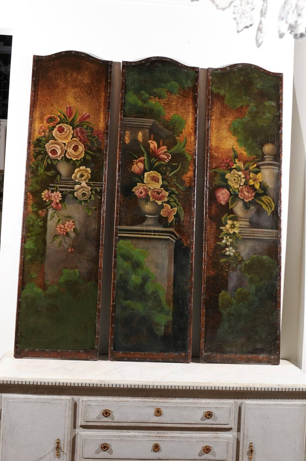 A set of three English leather painted panels with floral and architectural motifs from the late 19th century. We were immediately charmed by this exquisite set of three decorative panels. Born in England during the 19th century, they each depict