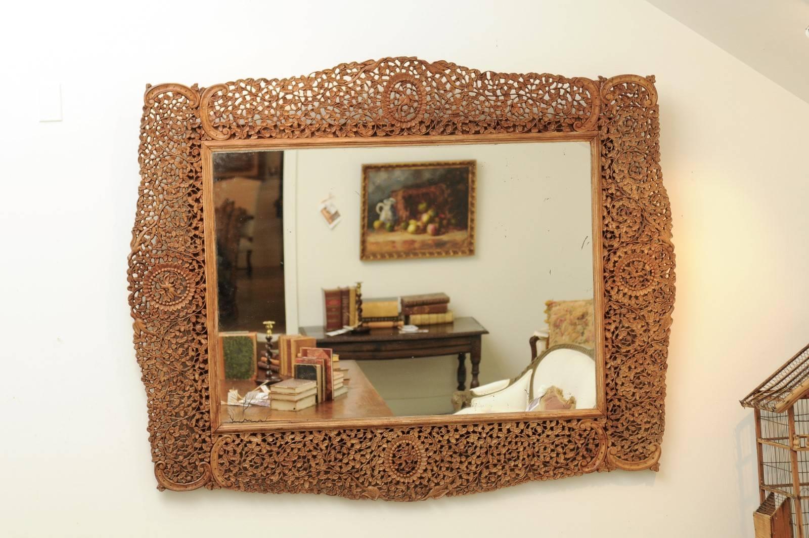 A wooden carved Burmese mirror with openwork design from the mid-19th century. This exquisite mirror was born in Myanmar, (former Burma) in the 1840s. Featuring an openwork design, the frame is adorned with a multitude of delicate rinceaux with