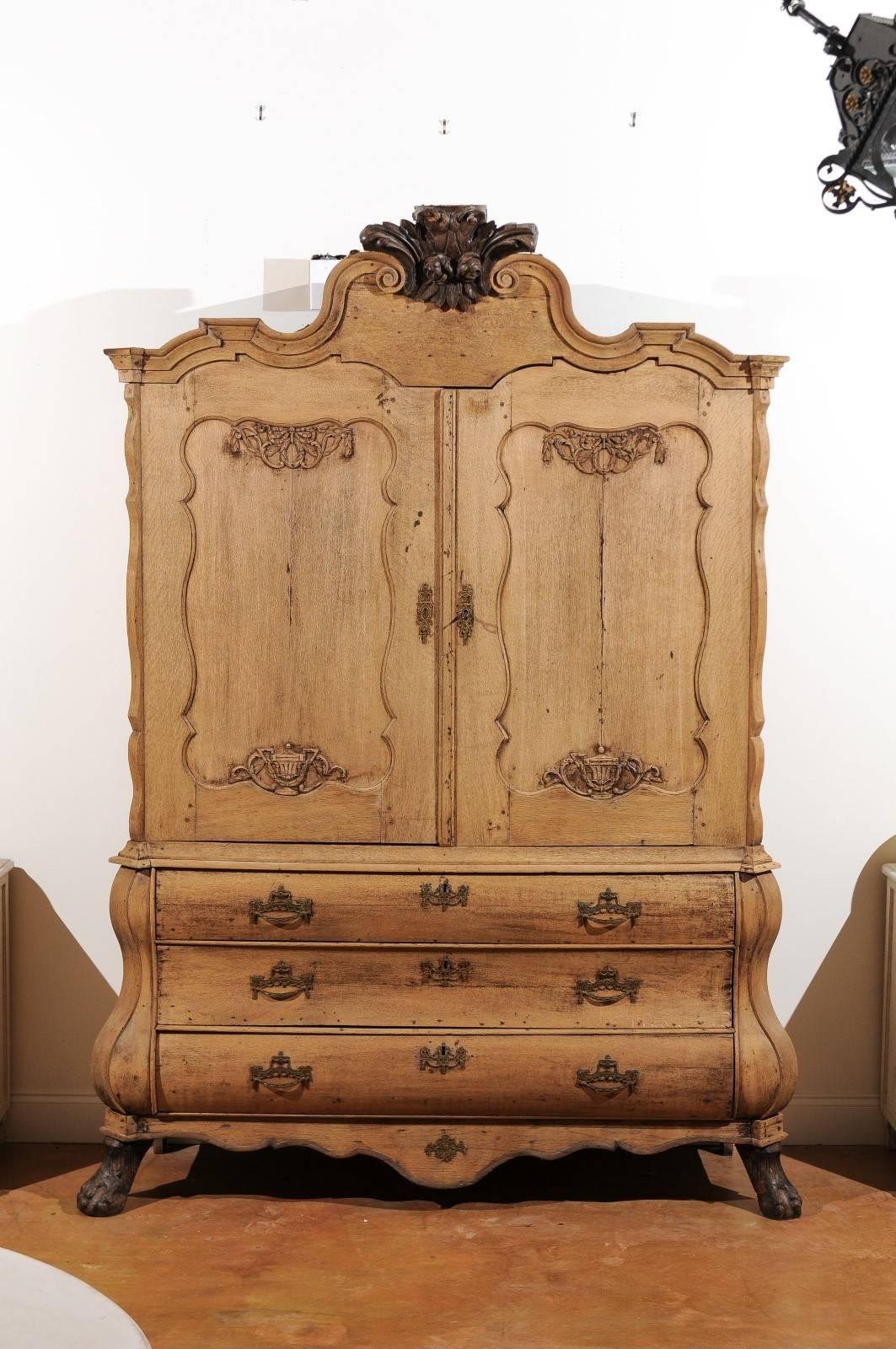 A Dutch Rococo mid-18th century bleached oak buffet à deux-corps with two doors over three drawers. This Rococo buffet à deux-corps circa 1740 features a beautifully carved crest with acanthus leaves and rosettes flanked by exquisite volutes. The