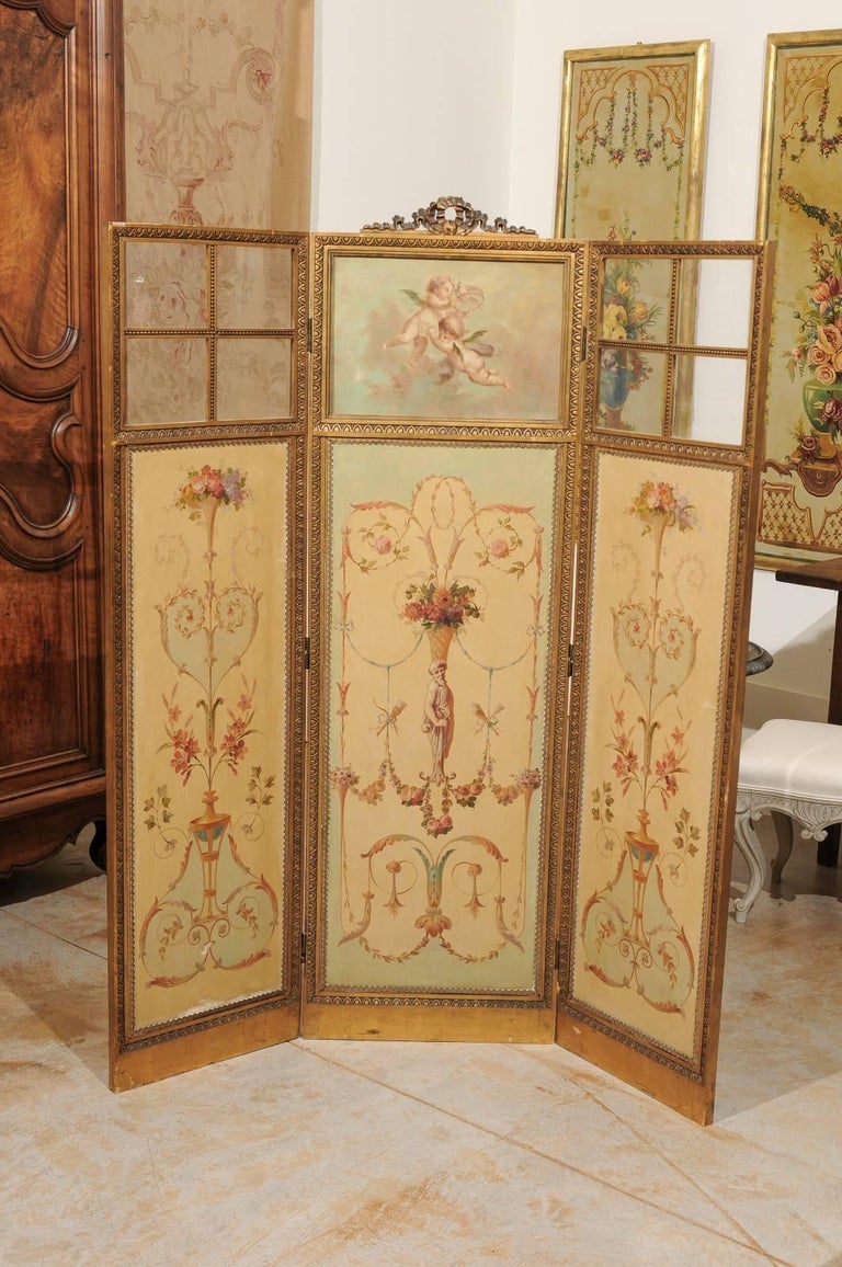 A French Renaissance Revival folding three-panel screen with hand-painted Grotesque motifs and inset glass from the 19th century. Reminding us of motifs that one would see on the ceiling of the Uffizi gallery in Florence, this French painted screen