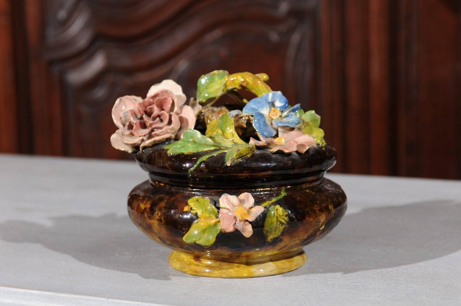 A French 19th century petite faience covered bowl with floral and bird's nest barbotine décor. This exquisite French pottery features a round dark brown body, adorned with an exuberant floral décor, typical of the barbotine productions. The