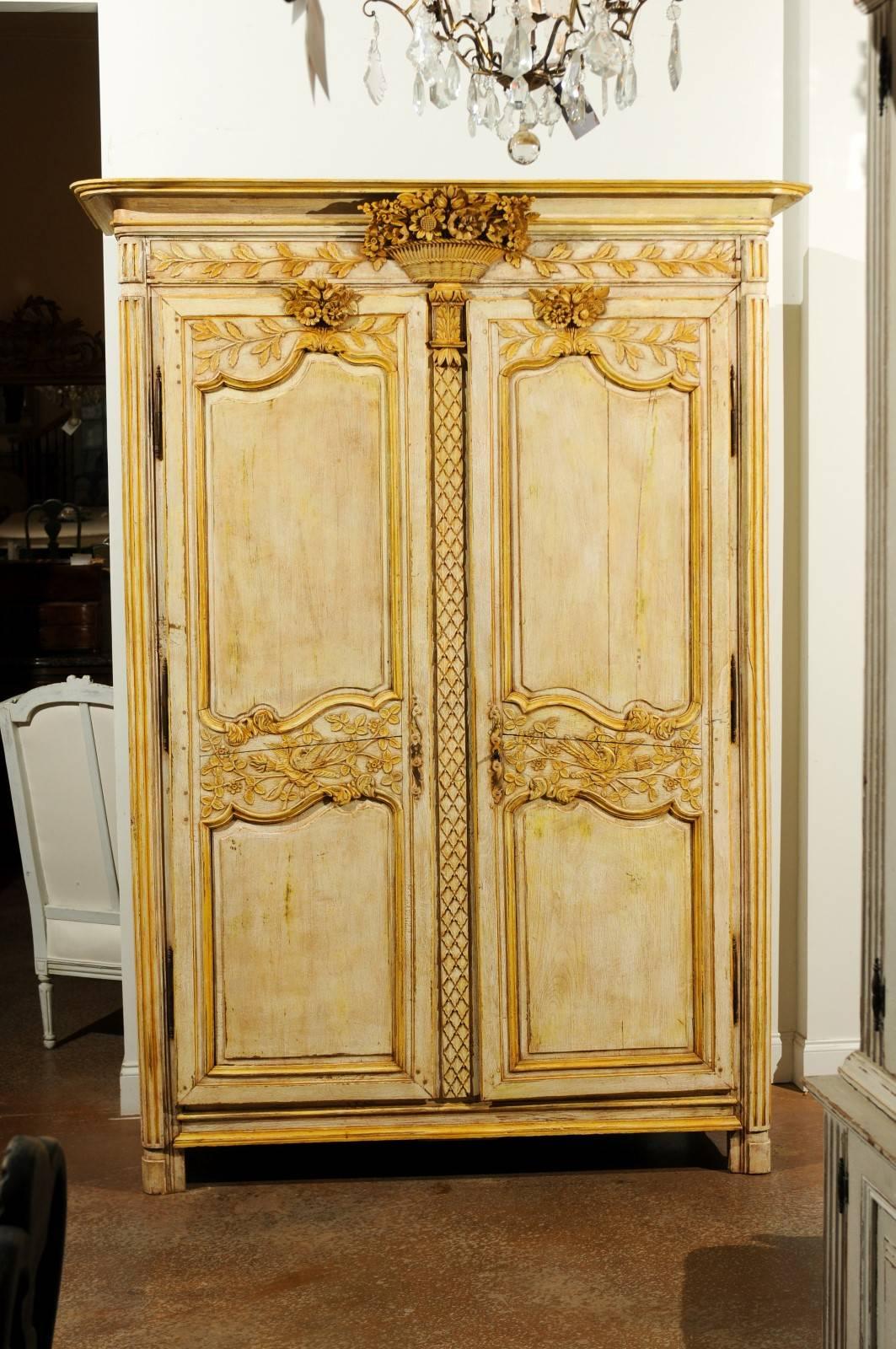 A French Transition period painted marriage armoire with floral carved cornice and doors from the mid-18th century. Delicately painted with goldenrod accents, this French armoire features an exquisite bouquet of flowers carving in the cornice,