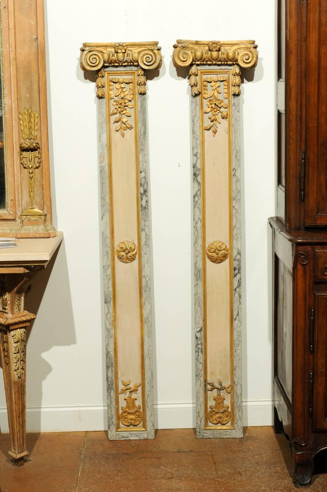 A pair of French 18th century Louis XVI decorative pilasters with Ionic style capitals, giltwood accents and faux marble borders. Each of this pair of French decorative pilasters features an eye-catching gilded Ionic capital, sitting above a linear