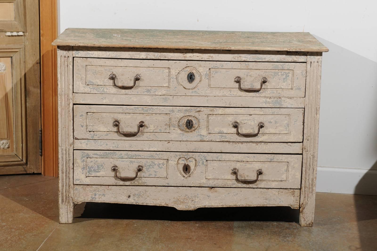 A petite French neoclassical Provençale white painted three-drawer commode from the early 19th century. Born in the early 1800s in the Southern French city of Aix-en-Provence, particularly dear to Cézanne (think the Mountain Sainte-Victoire) this
