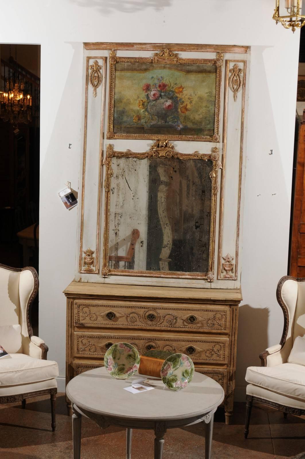 A French Louis XV style painted wood trumeau mirror from the mid-19th century. This French trumeau mirror features a linear silhouette, made of a light grey painted wooden frame, accented by delicate giltwood motifs and surrounding an exquisite