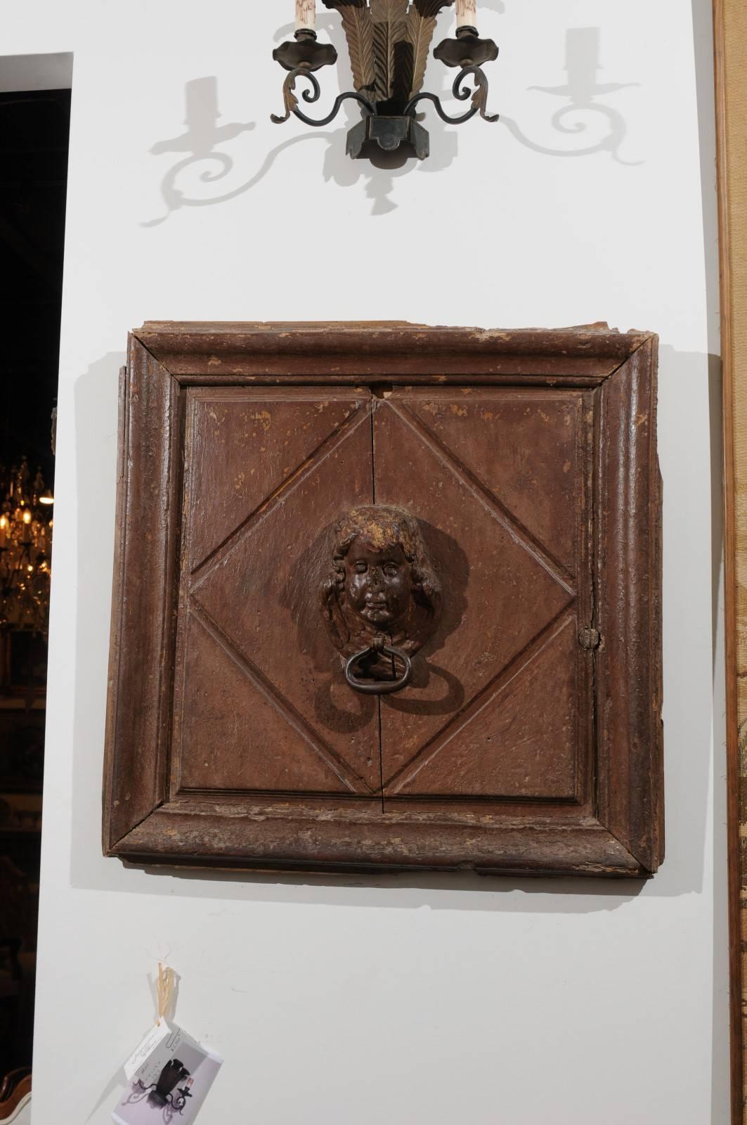 A pair of French 17th century square wooden wall fragments with high relief cherub carvings. Each of this pair of architectural pieces features a cherub face carved in high relief, surrounded by a diamond motif. The grand simplicity of the lines is