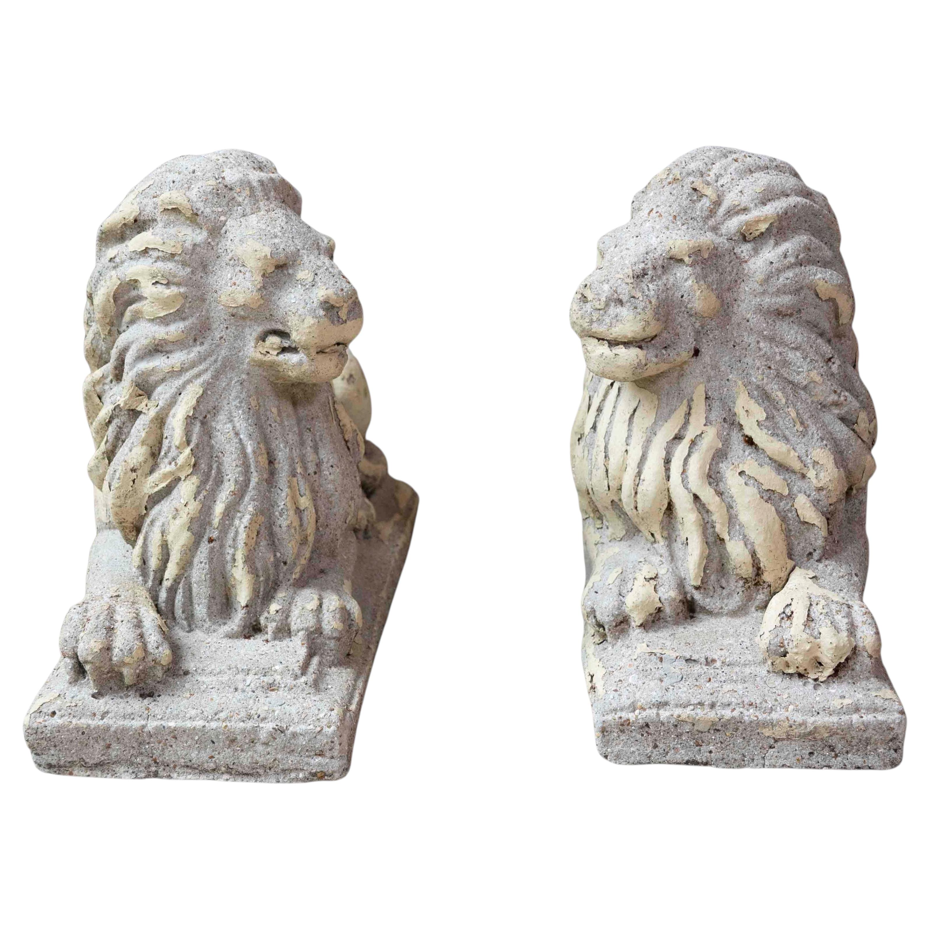 Paire de sculptures anglaises du XXe siècle représentant des lions allongés, de composition libre, avec patine