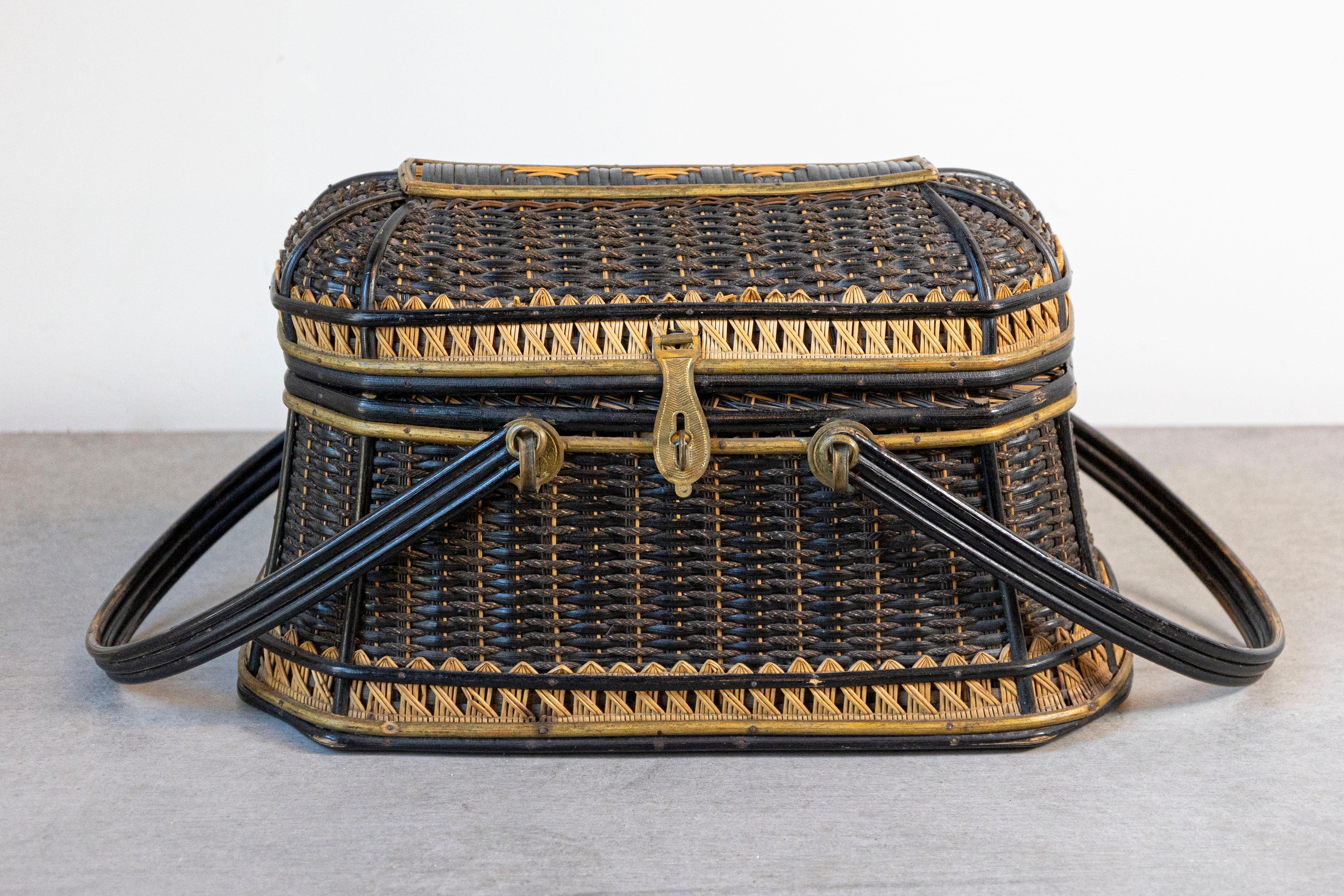 A Swedish two-toned wicker basket from the late 19th century, with two large handles and brass lock. Charming us with its rustic appearance and contrasting colors, this Swedish basket features an oval lid opening thanks to an elegant brass lock to