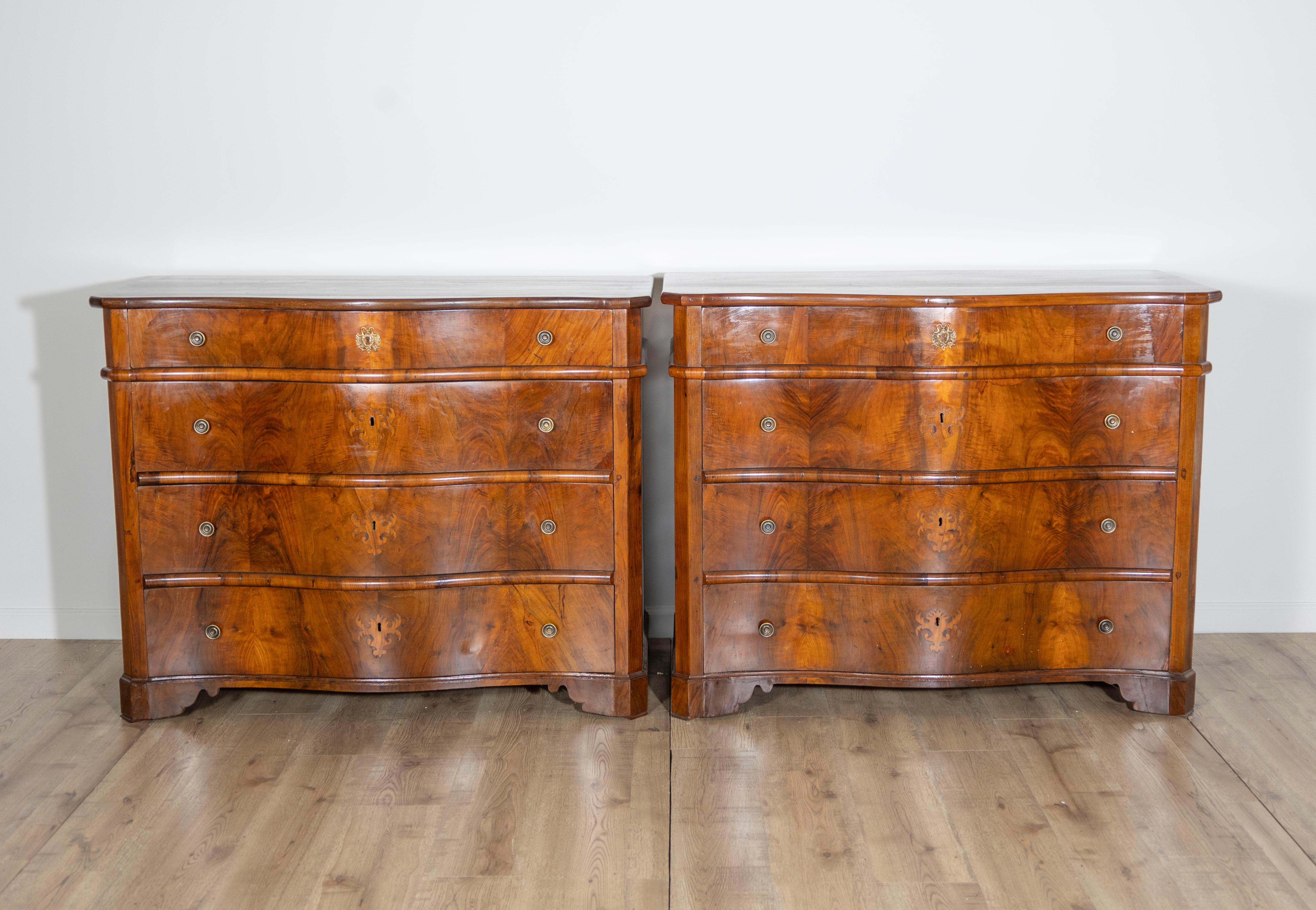 A beautifully preserved pair of 18th-century Italian commodes from Southern Italy, crafted in richly grained walnut with exquisite attention to form and symmetry. The serpentine fronts give these chests a sense of fluidity and movement, while the