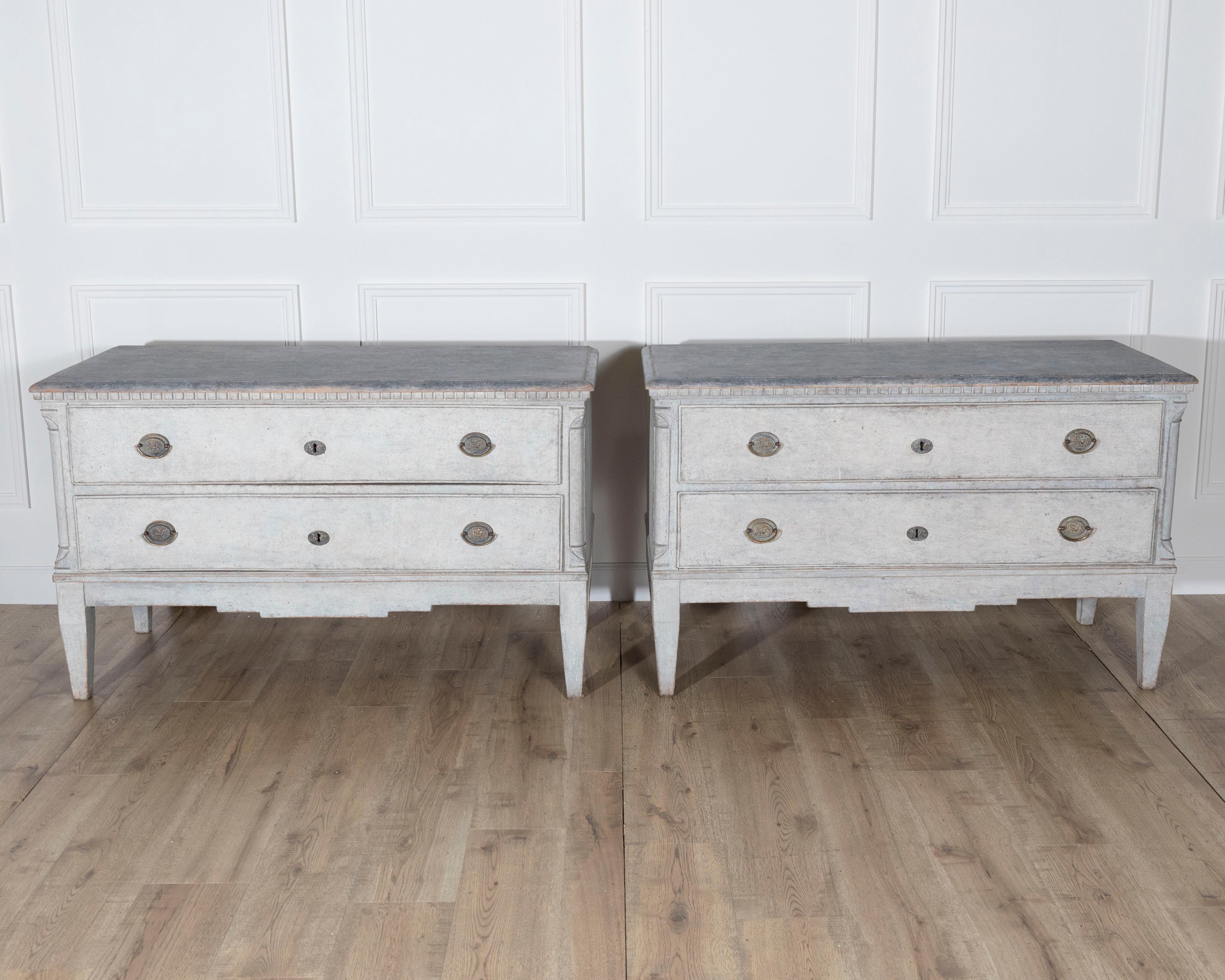 A handsome pair of Danish chests of drawers in beautifully patinated grey paint, crafted in the late 19th century. The tops are painted in a deeper shade of grey, offering elegant contrast to the lighter body below. Each chest features two spacious